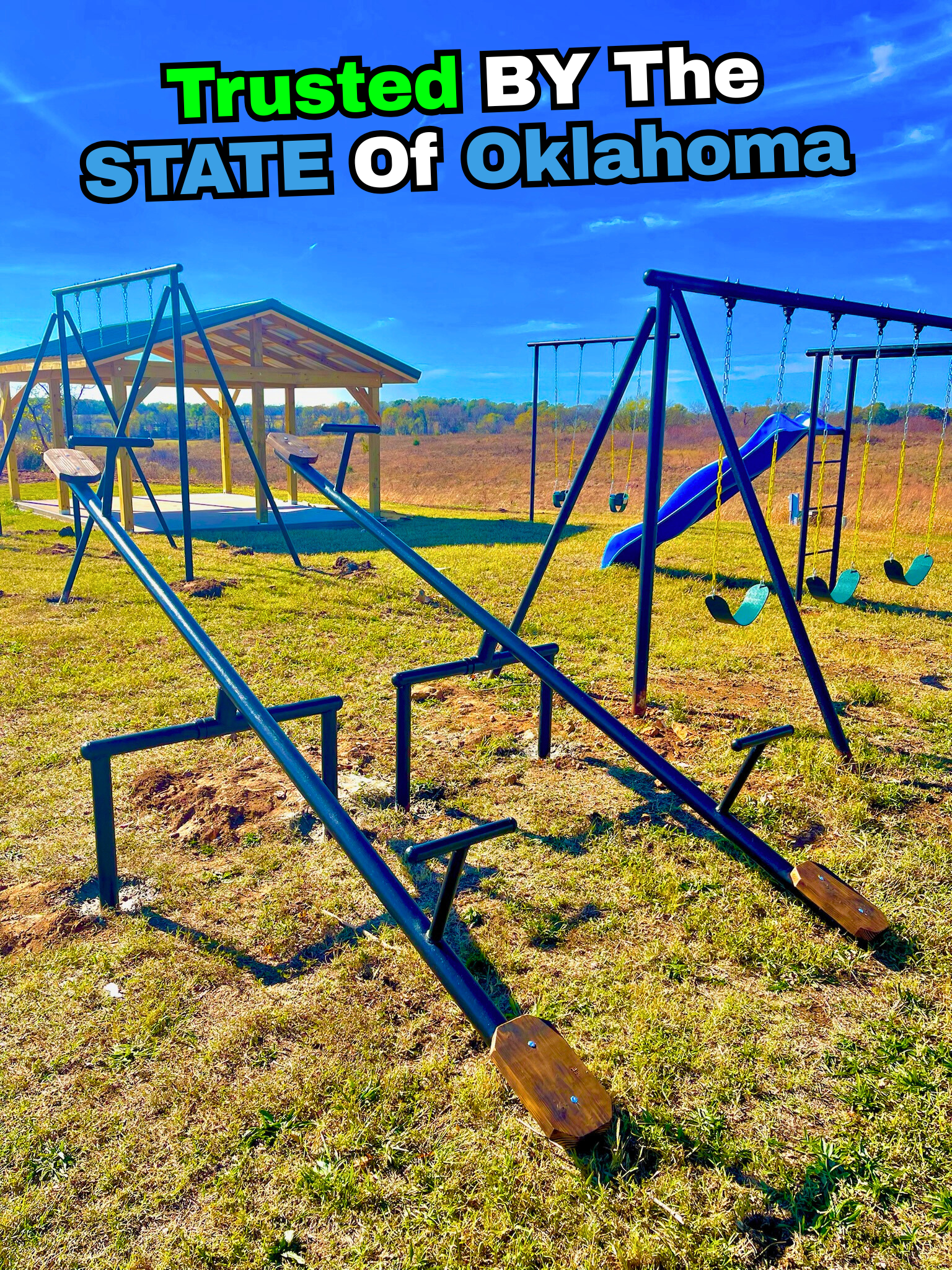 Empty playground with swings and slide, under a blue sky, with a shelter in the background, and the text 'Trusted BY The STATE of Oklahoma' at the top.
