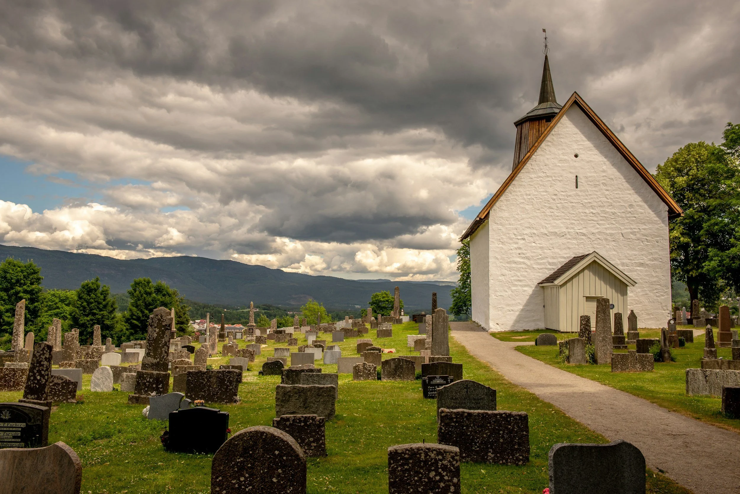 Image of a church graveyard overlooking a mountain in the background