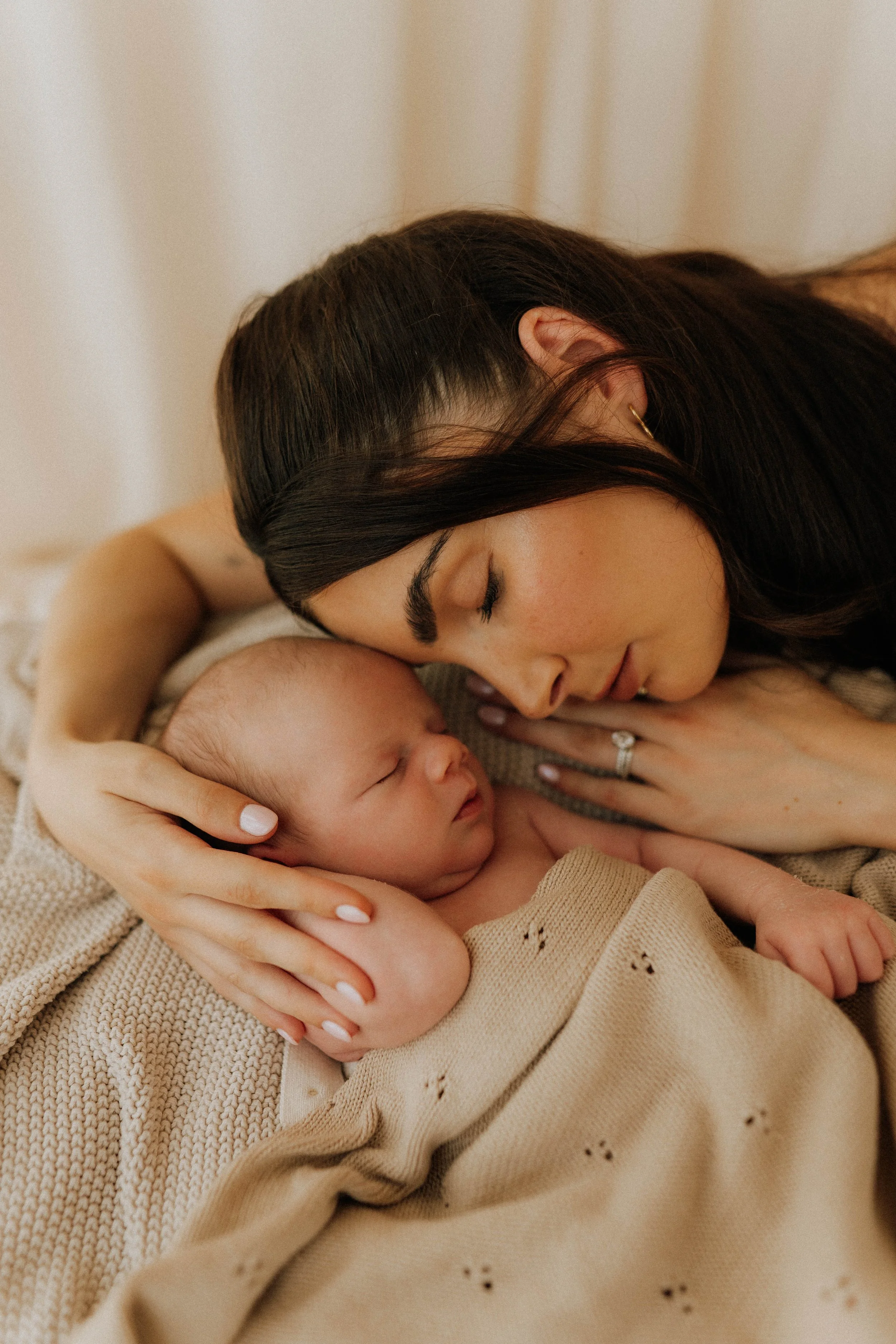 Image of a mother and newborn baby on their newborn shoot in Didsbury Family Photography Studio