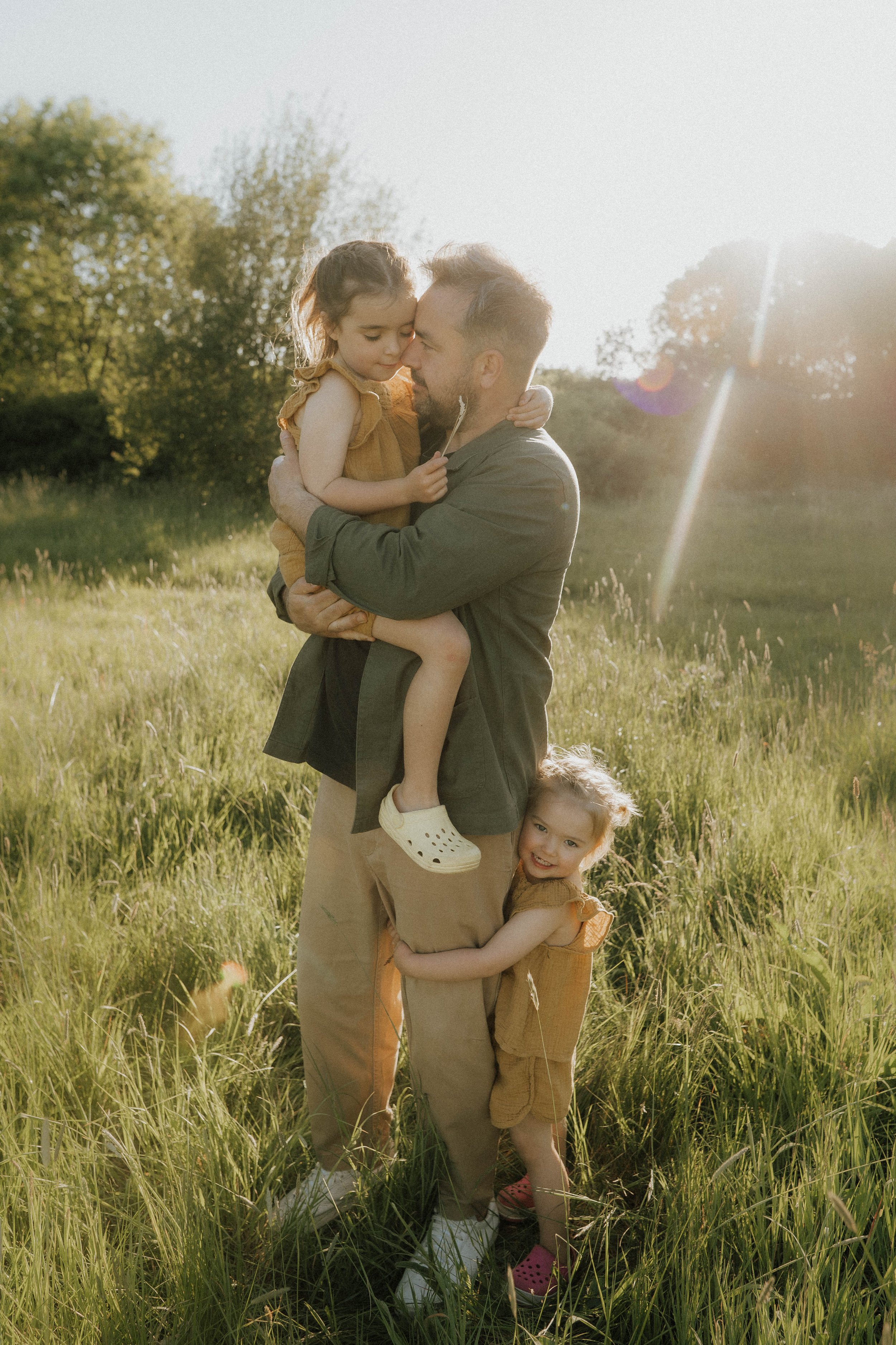 image of a dad with his two young girls on their family shoot in Didsbury with Didsbury family photographer Copper + Olive Photo