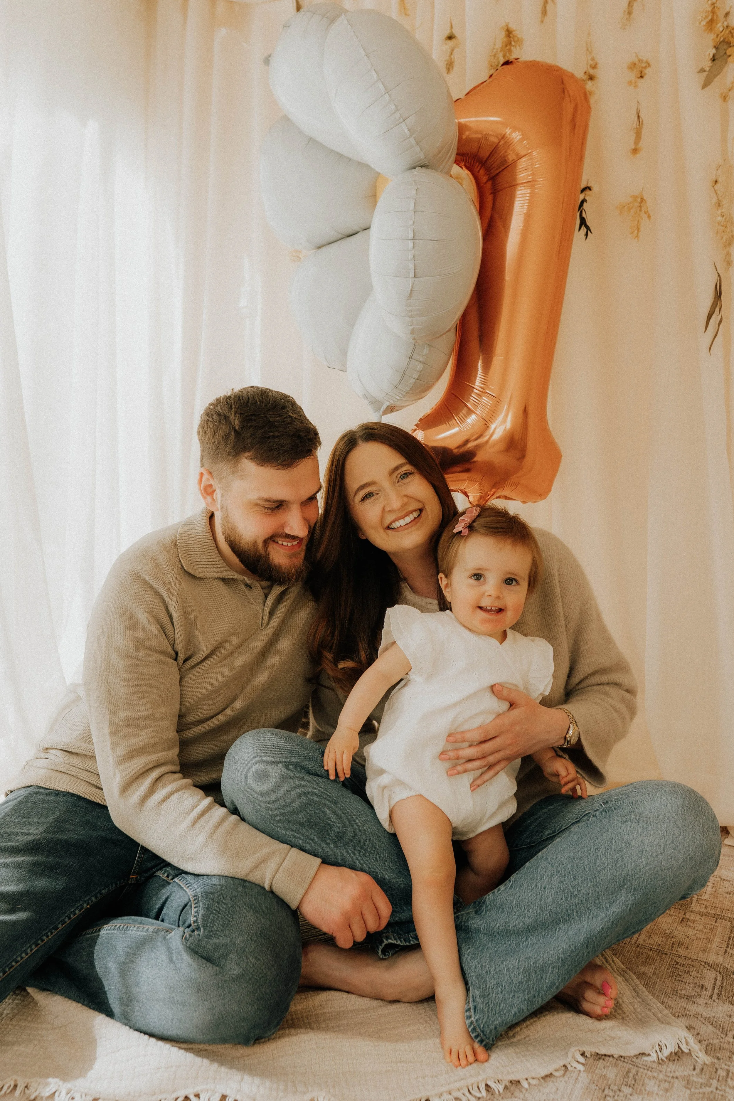 Image of a family of three on their daughter's first birthday shoot at Didsbury Family Photography Studio