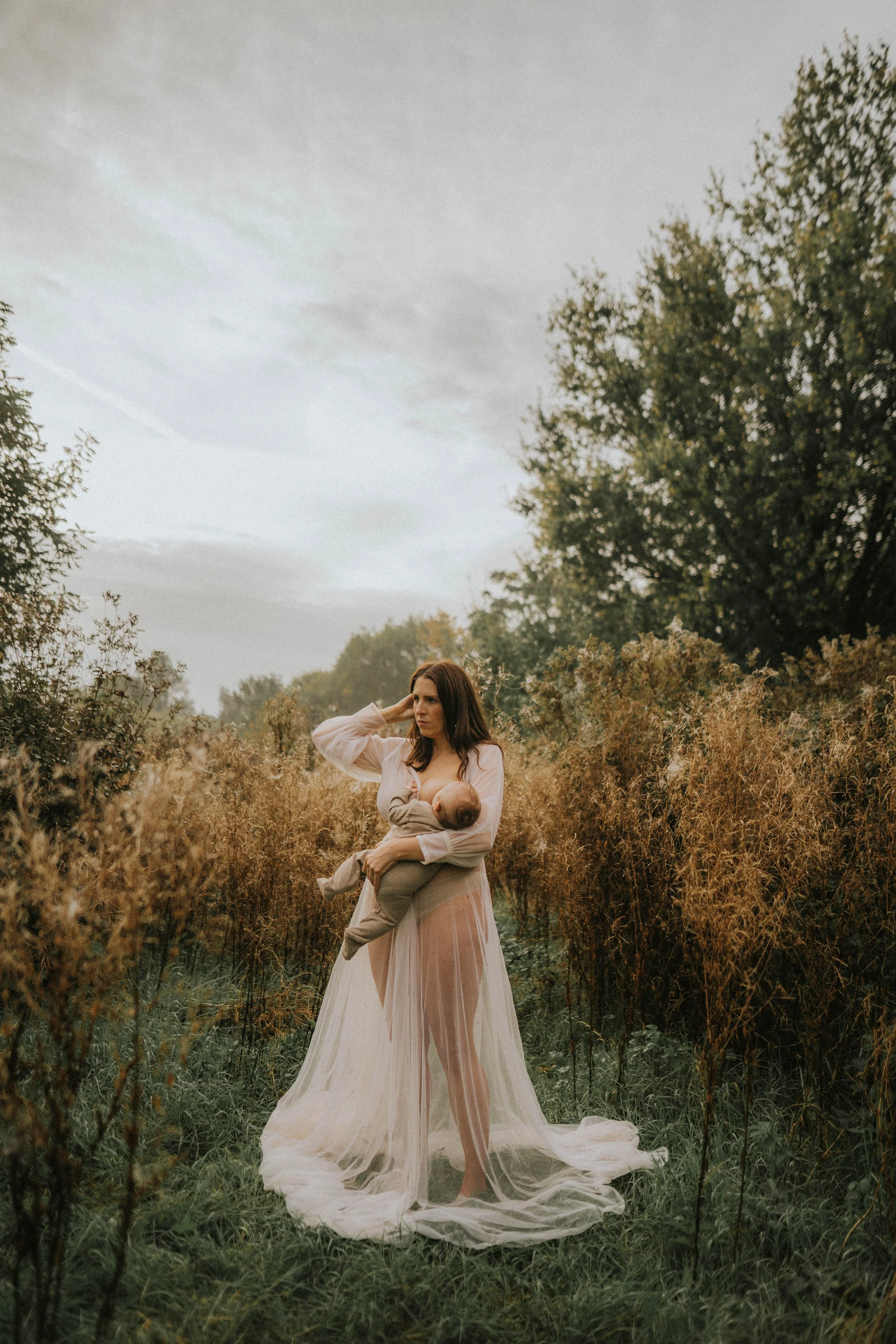 image of a nursing woman in a beautiful dress on her motherhood shoot in Didsbury Manchester