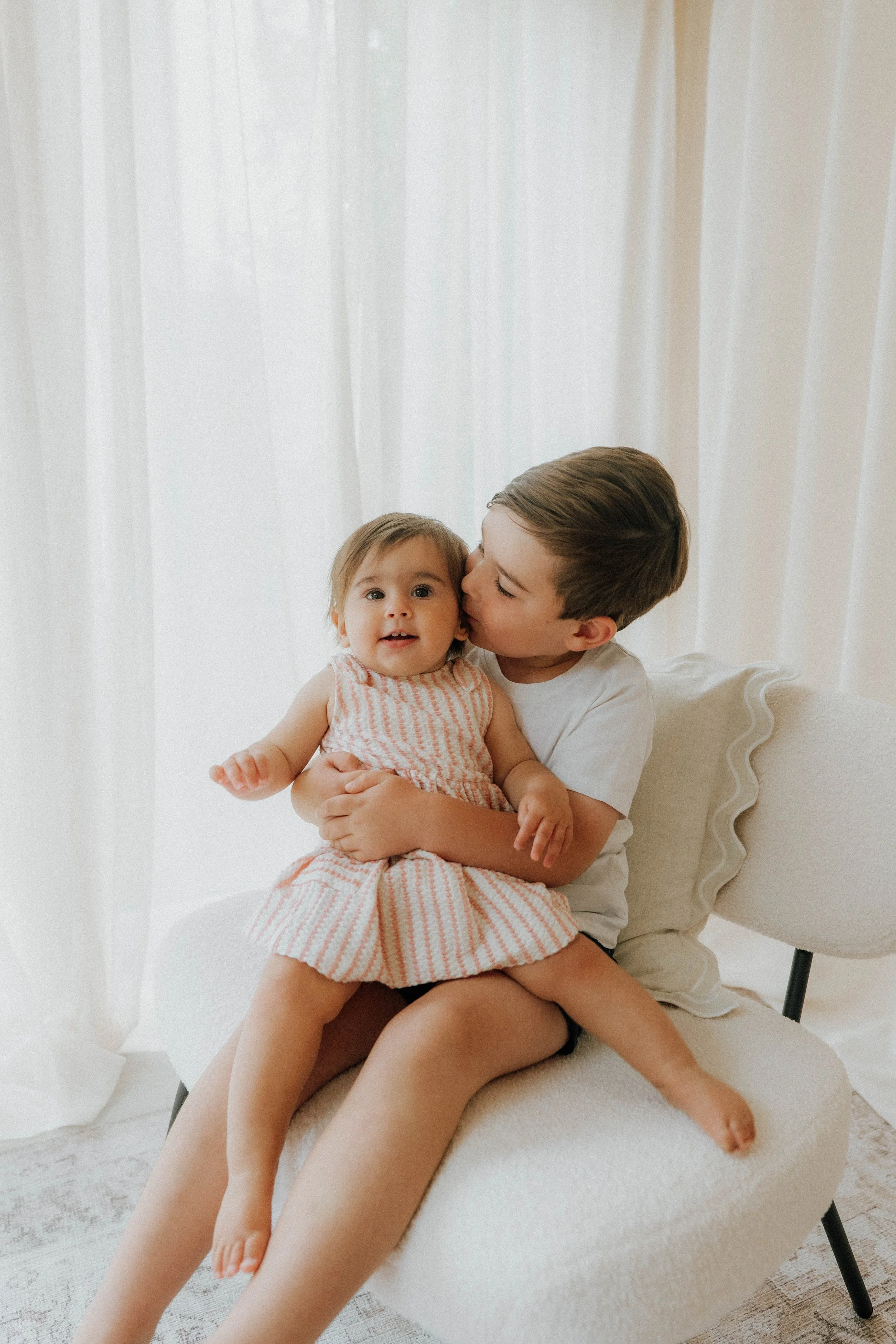 Image of a brother and sister cuddling at their family shoot at Didsbury Photography Studio