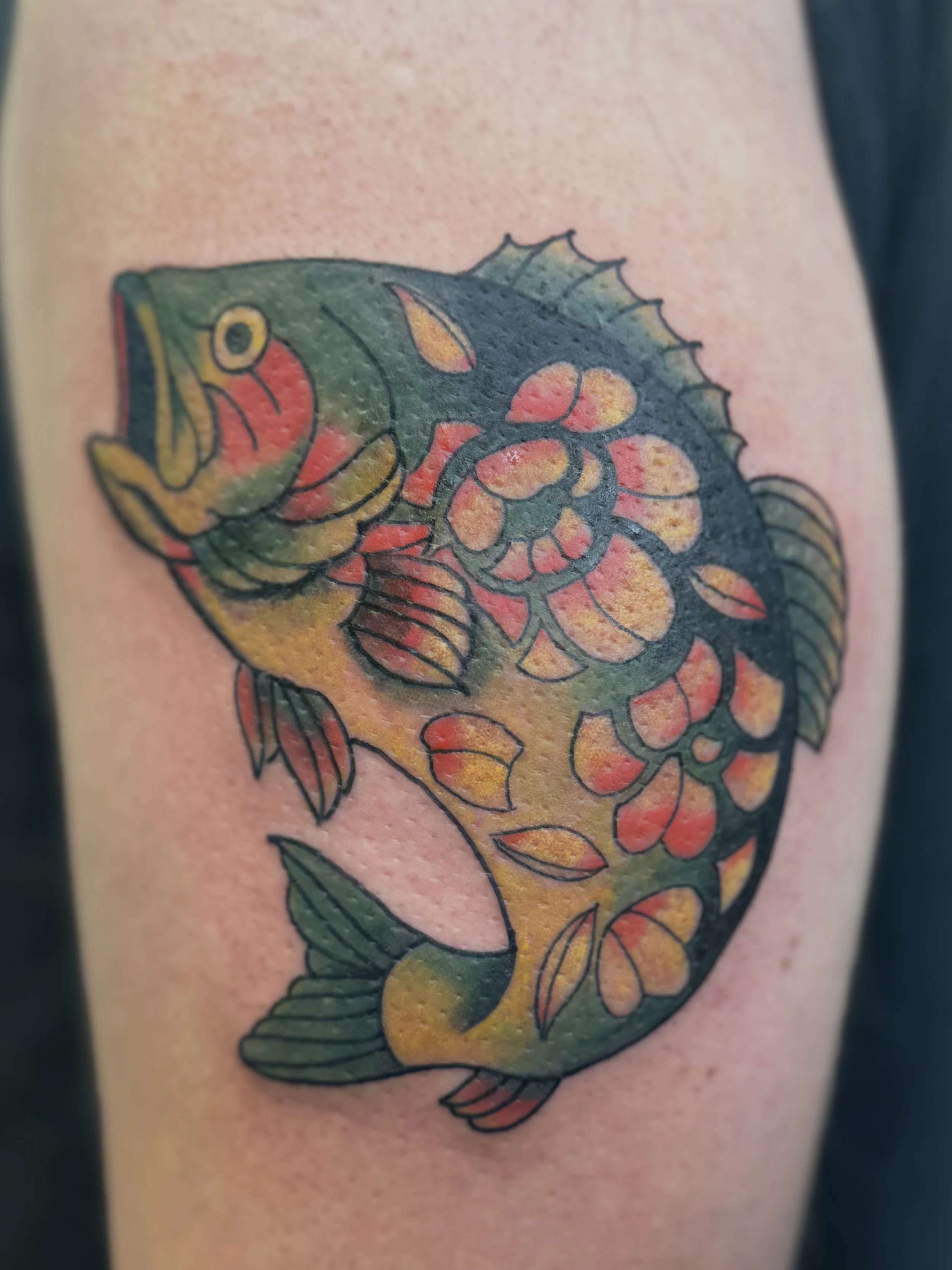 Colorful tattoo of a fish on skin with detailed fins and scales.