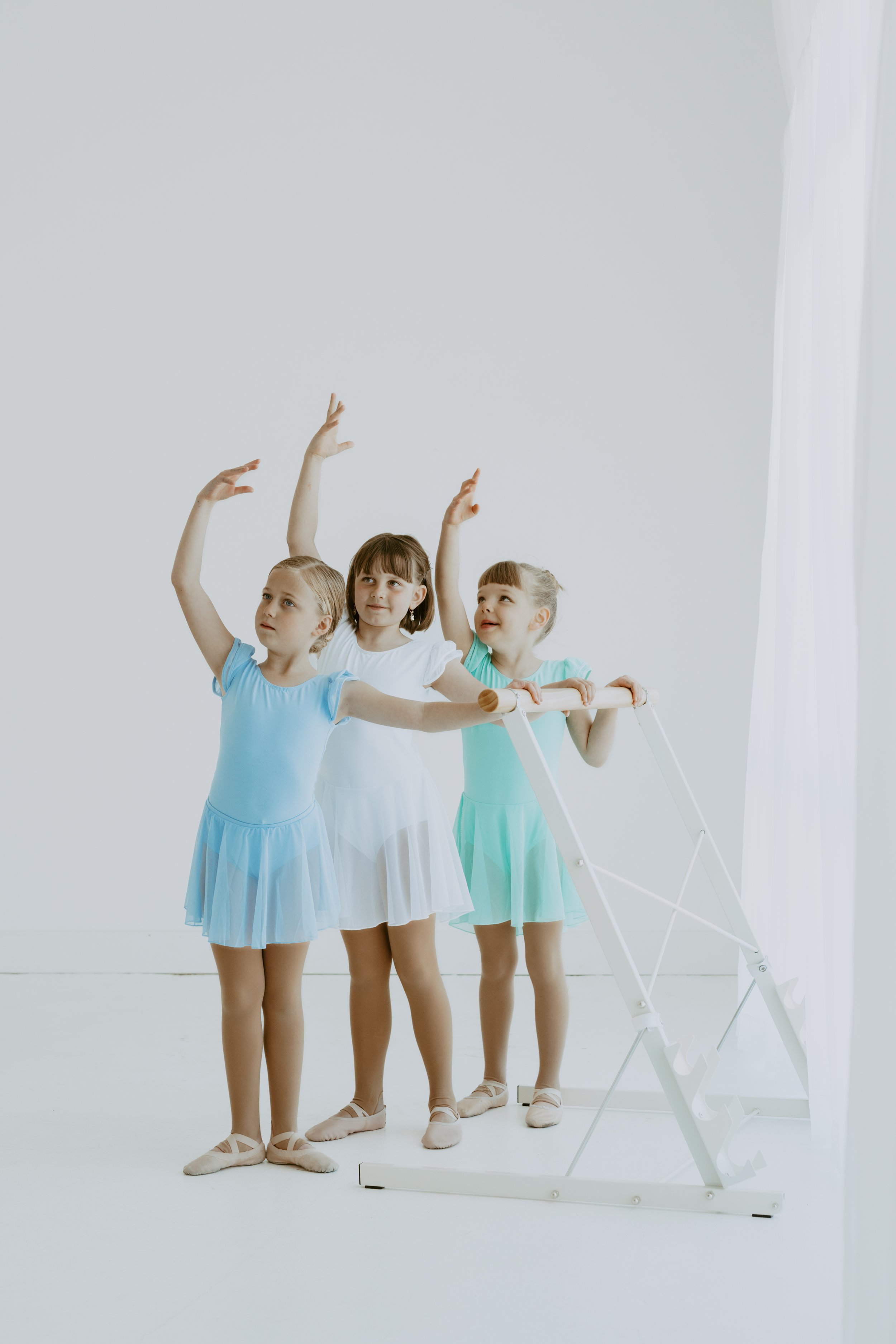 Three girls dancing in a ballet class