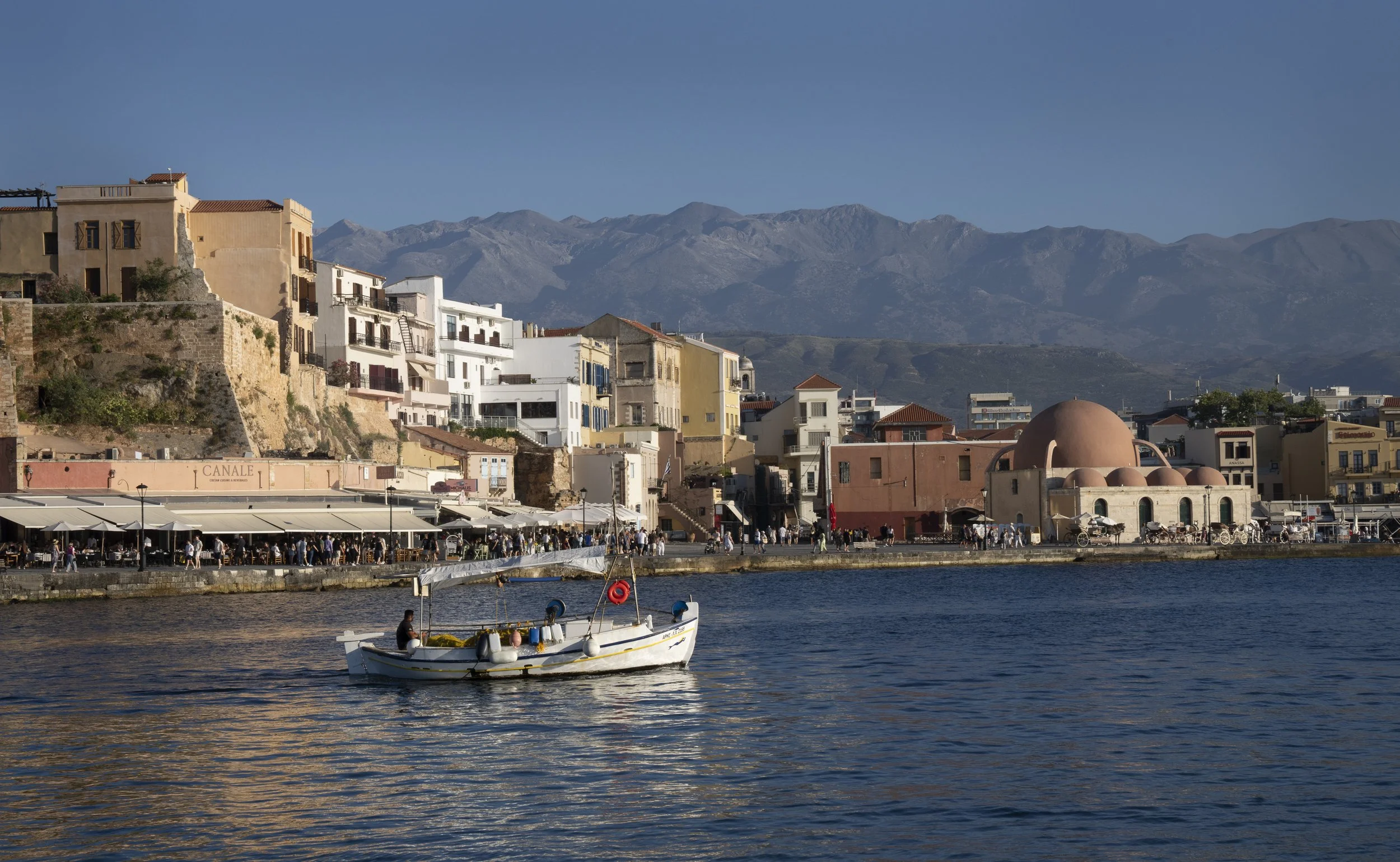 Fisherman motoring out to sea. Old Venetian Harbor, Chania, Crete, Greece