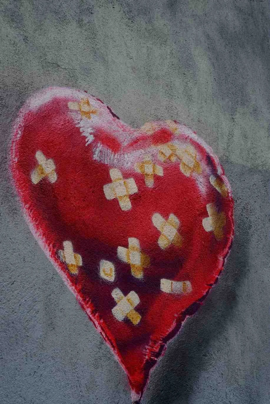 Red heart with bandages painted on a wall, symbolizing emotional wounds, trauma healing, anxiety recovery, and restoring emotional resilience through EMDR and Brainspotting therapy in Oklahoma City.