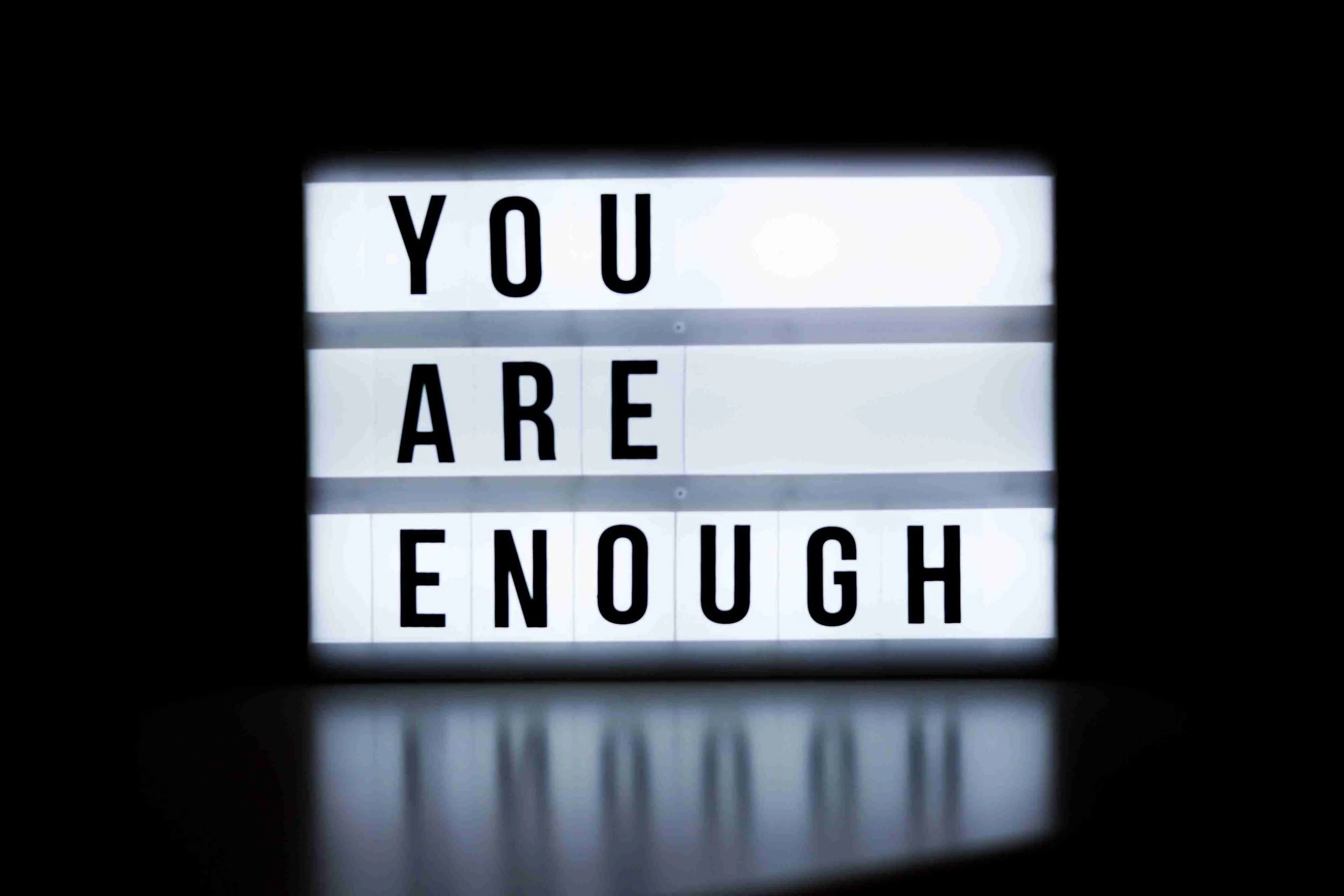 Lightbox sign displaying the words “You Are Enough” against a dark background, symbolizing healing from self-criticism, low self-worth, anxiety, and the inner critic through trauma-informed therapy in Oklahoma City.