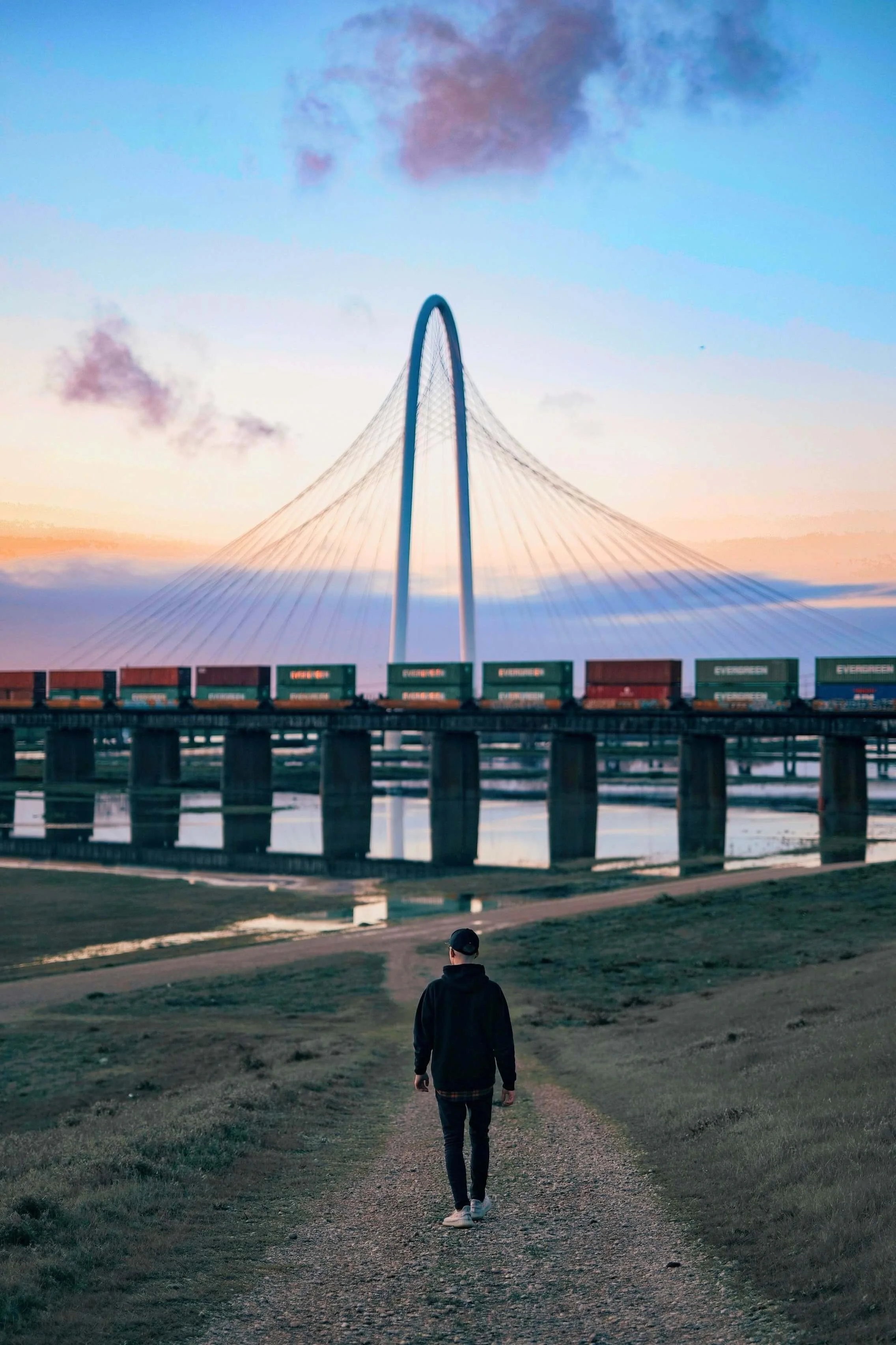 Person walks toward sunset bridge in Dallas, Texas, symbolizing focused EMDR intensives for faster, deeper trauma and PTSD healing.