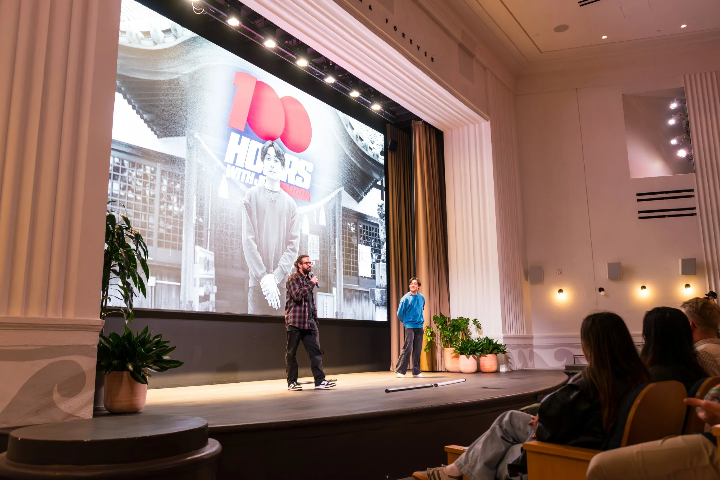 Motorcyclist performing a mid-air stunt on a dirt bike against a cloudy sky.