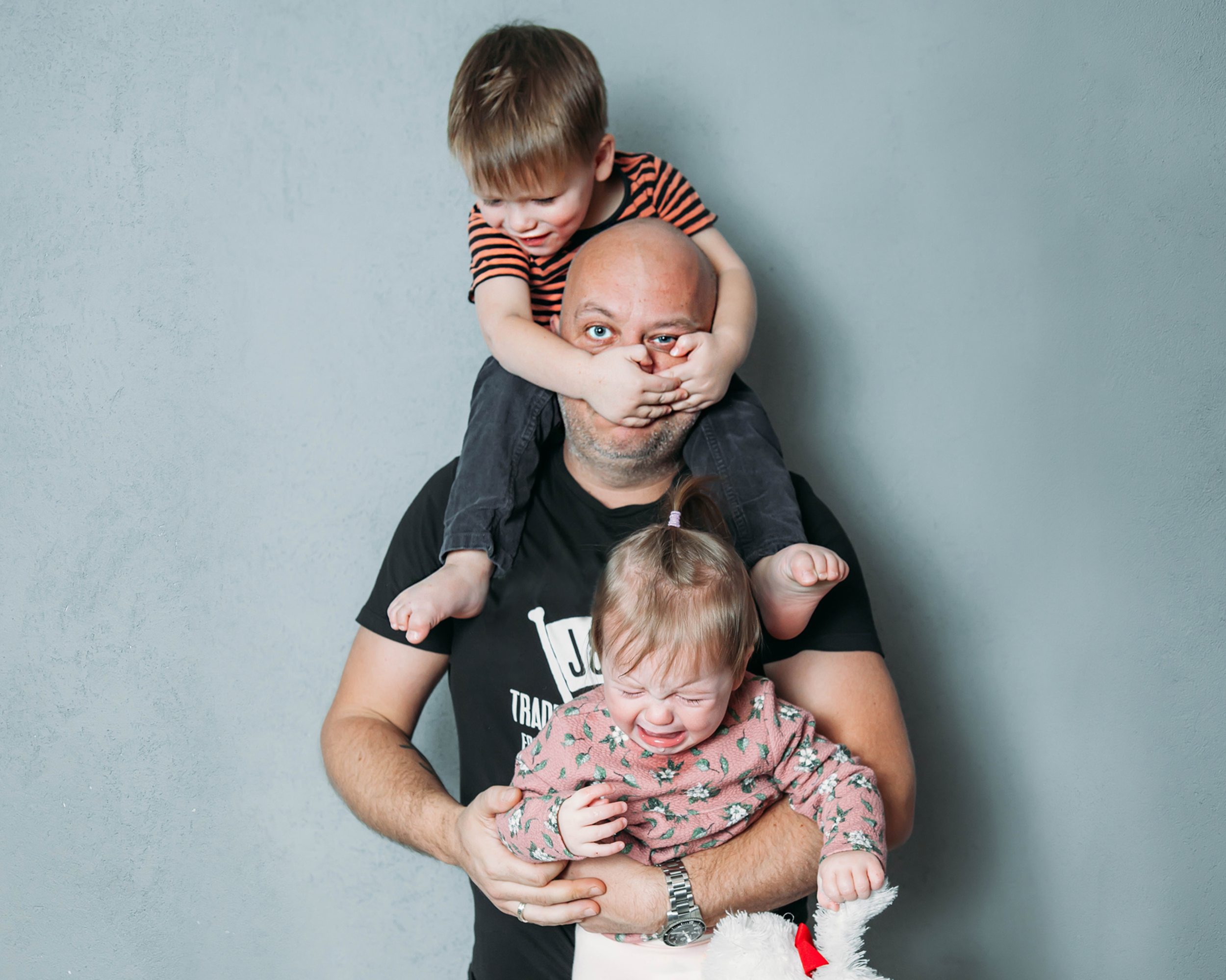 A father holding his children through a difficult moment — illustrating the parenting realities Nanny Connie helps families navigate through her coaching and her four-decade philosophy: Just be the parent.