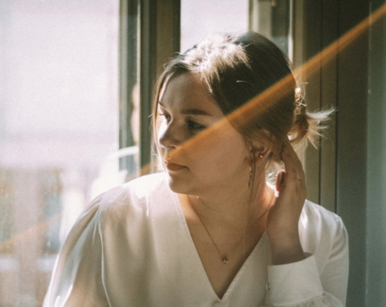 Woman reflecting while looking out a window