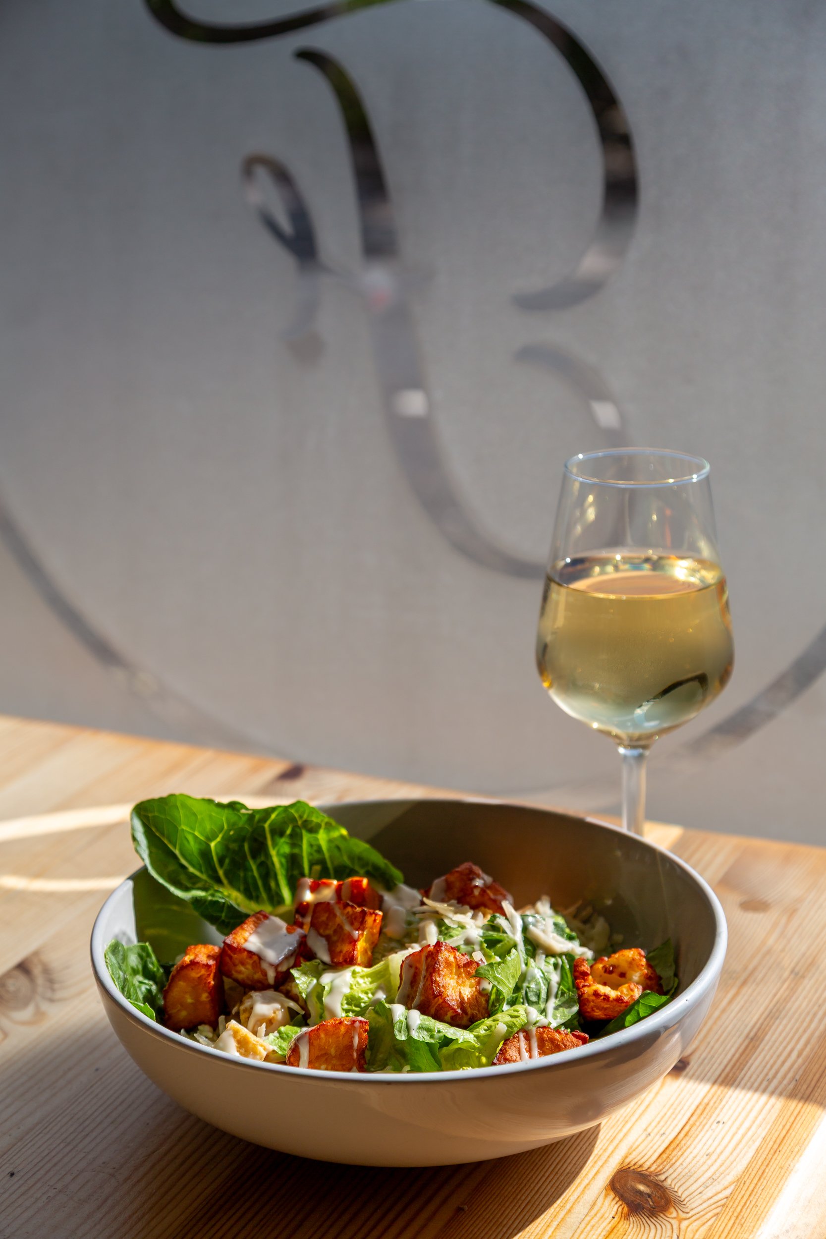 Halloumi caesar salad with white wine at The Folly Wine Bar in Petersfield, Hampshire. Food photography by Sequoia Studios.