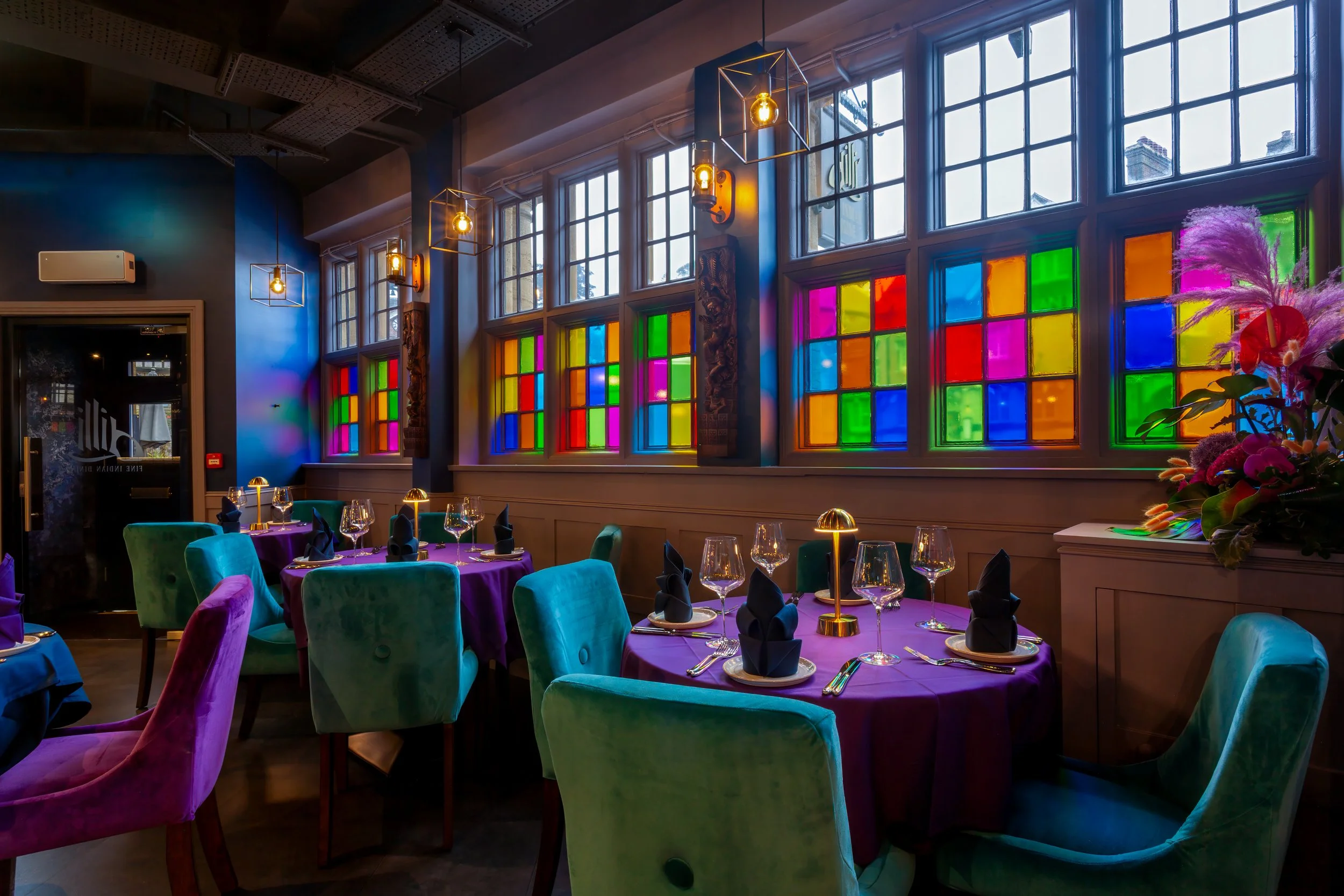 Interior dining room lit by colourful glass windows – The Dilli, Haslemere, Surrey – Restaurant Photography by Sequoia Studios