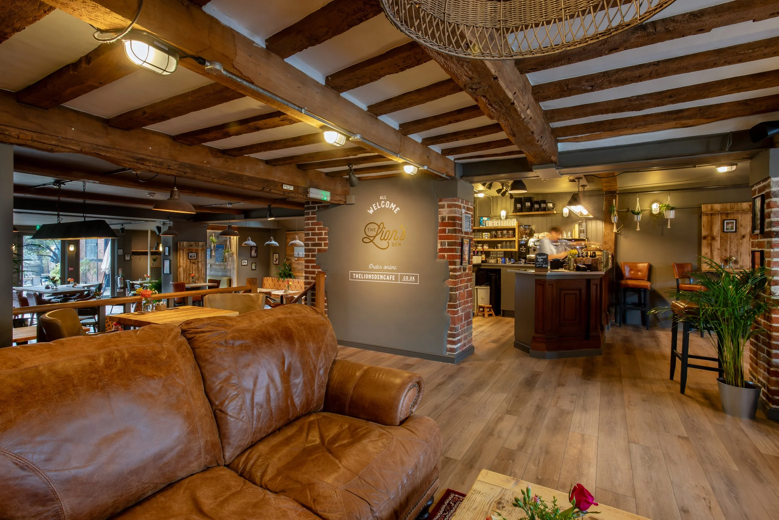 Wide angle of leather sofa and café counter – The Lion's Den Midhurst – Hospitality Venue Photography by Sequoia Studios