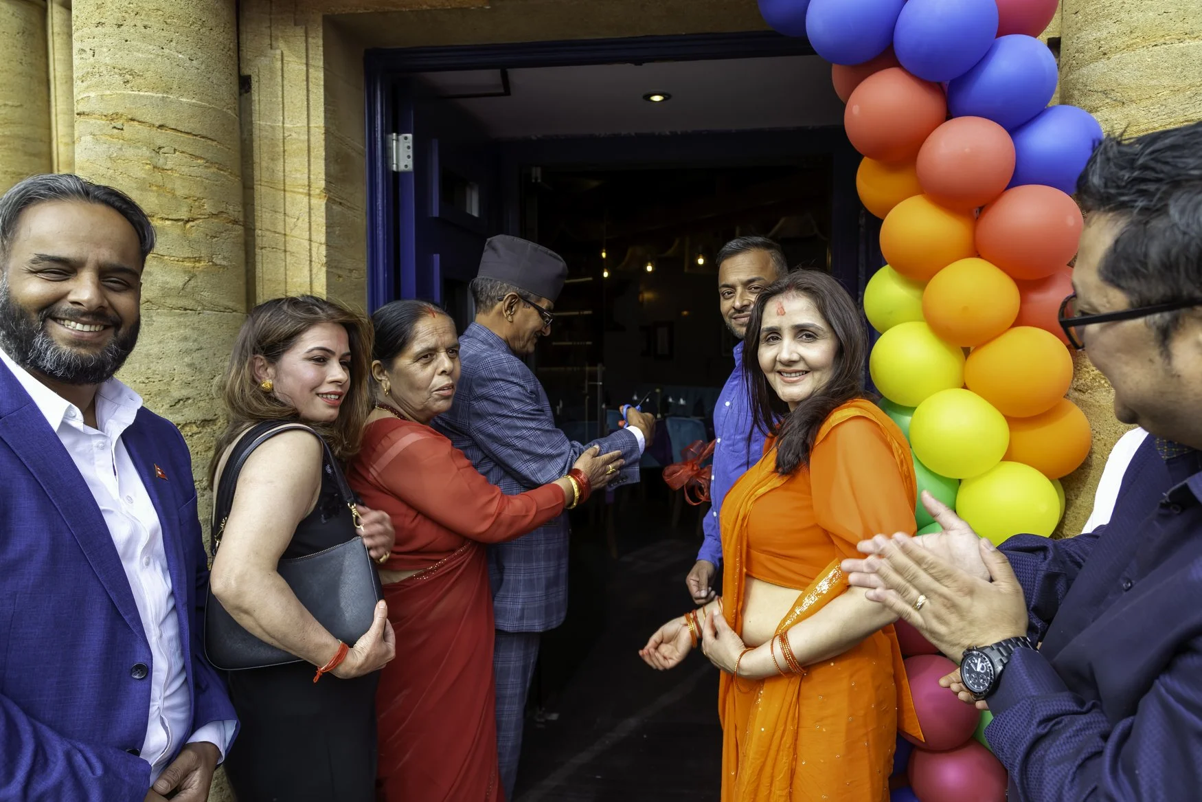 Ribbon cutting ceremony with colourful opening day balloon garland and smiling owners – The Dilli, Haslemere – Restaurant Photography by Sequoia Studios