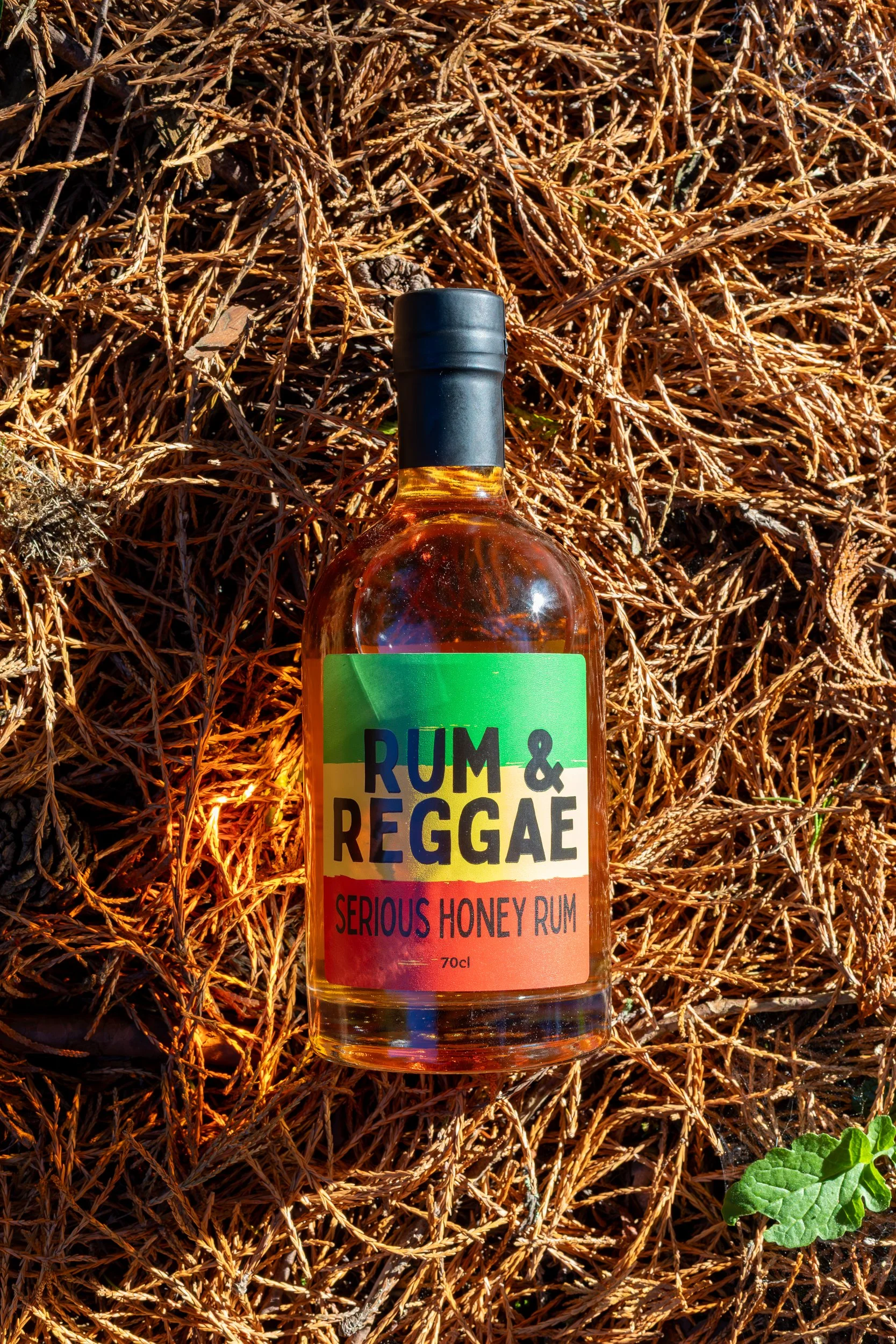 Rum &amp; Reggae Serious Honeyl Rum product shot on old pine needles