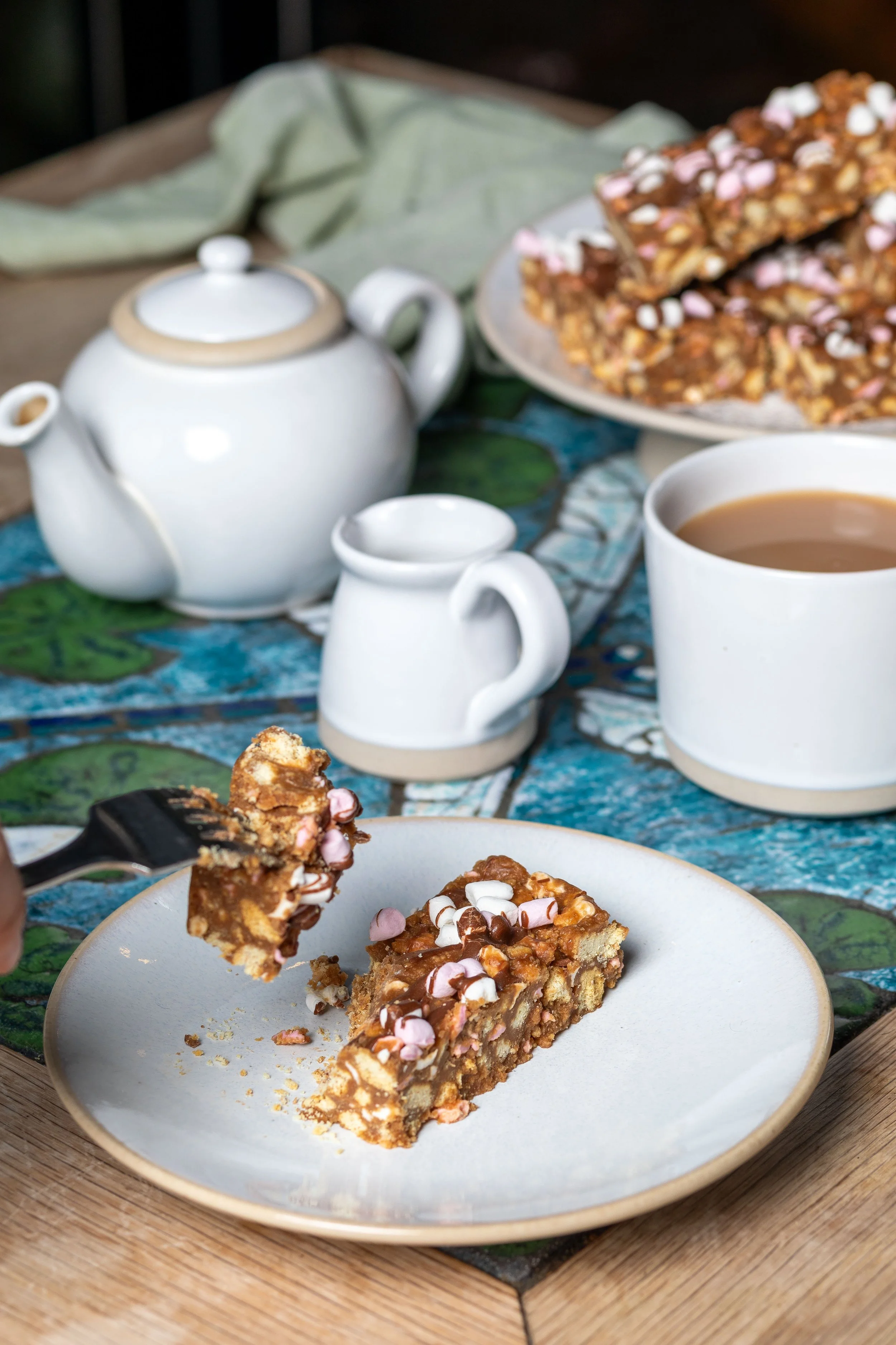 Rocky road slices with piece on fork with tea at The Kiln Cafe served with crockery handmade at Grayshott Pottery