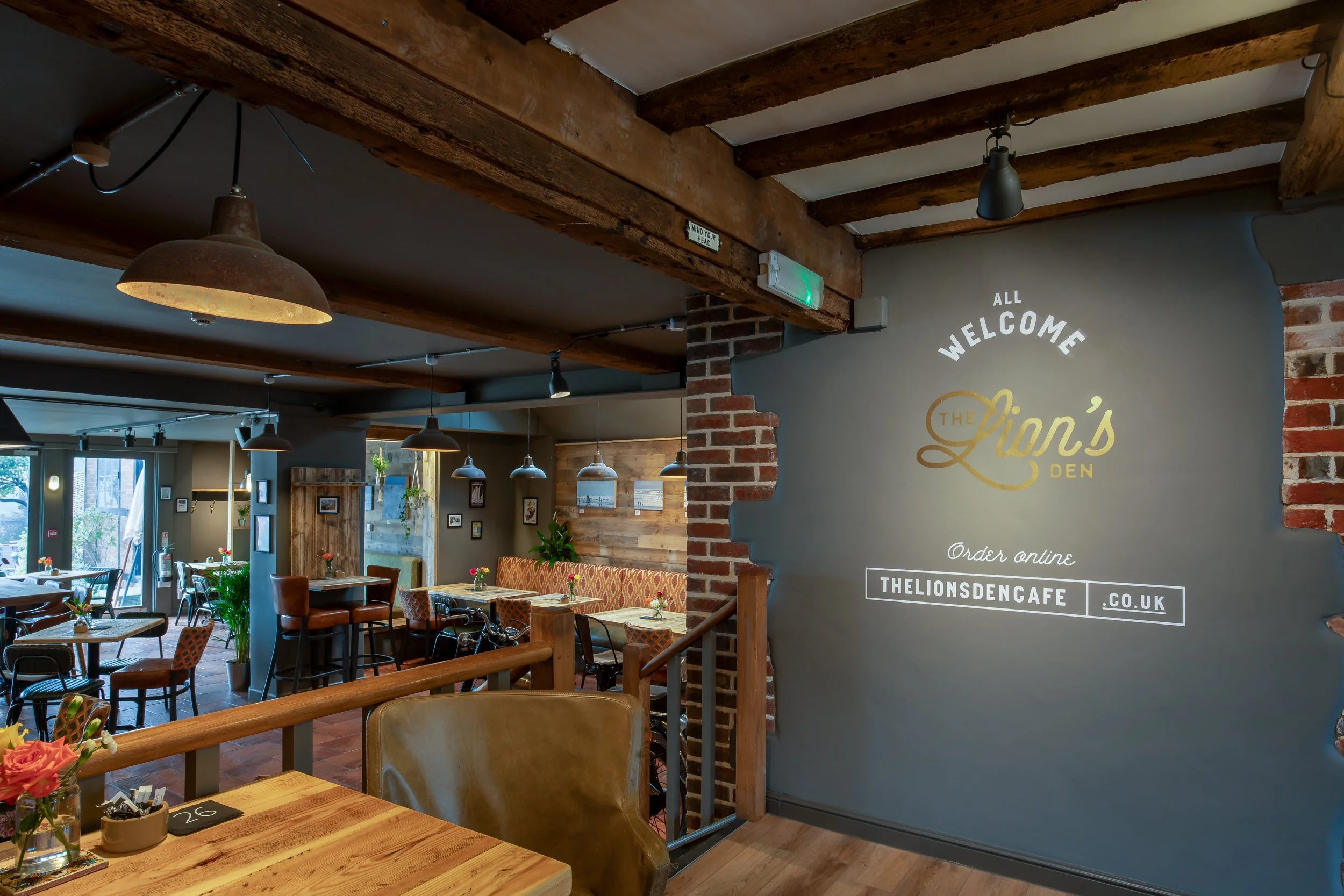 Wide shot of interior with large wall featuring logo – The Lion's Den Midhurst – Hospitality Venue Photography by Sequoia Studios