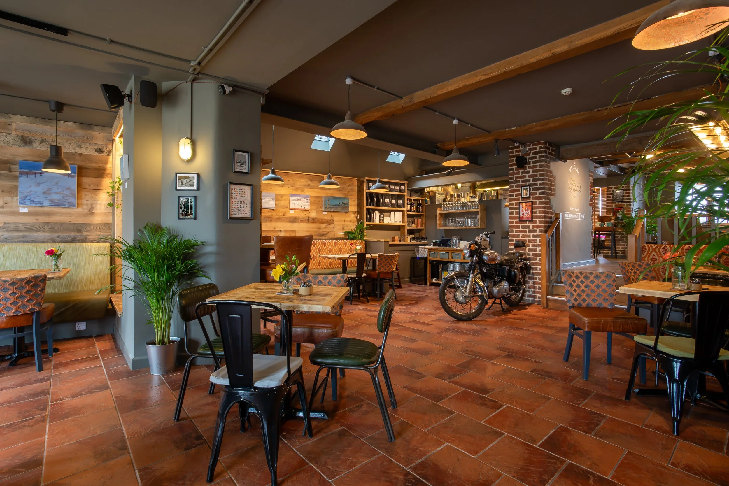 Wide angle of café interior featuring Royal Enfield motorcycle shot from rear – The Lion's Den Midhurst – Hospitality Venue Photography by Sequoia Studios