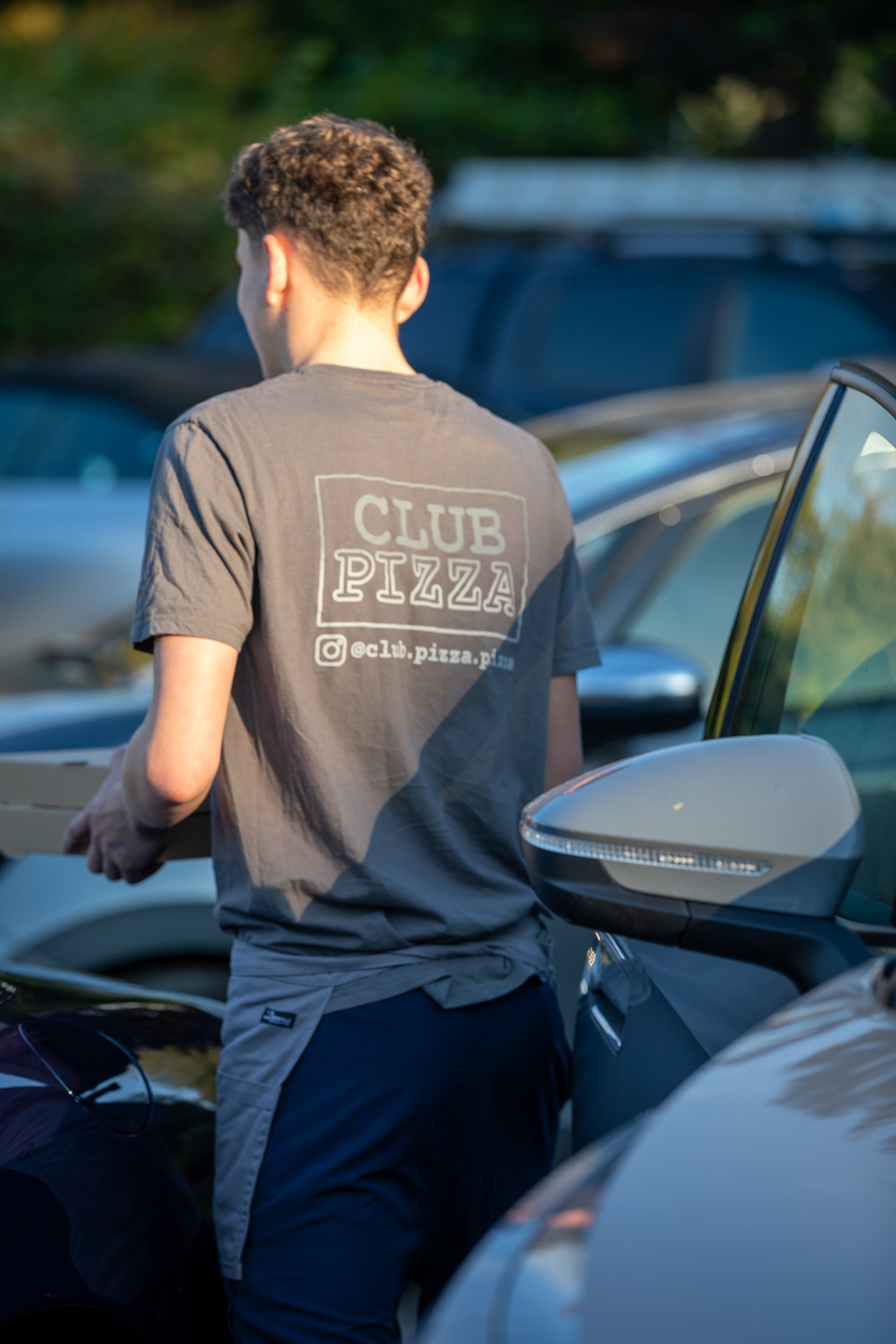 Club Pizza staff delivering pizzas to customer in their car at The Crossways Inn, Churt, Surrey. Lifestyle & food photography by Sequoia Studios