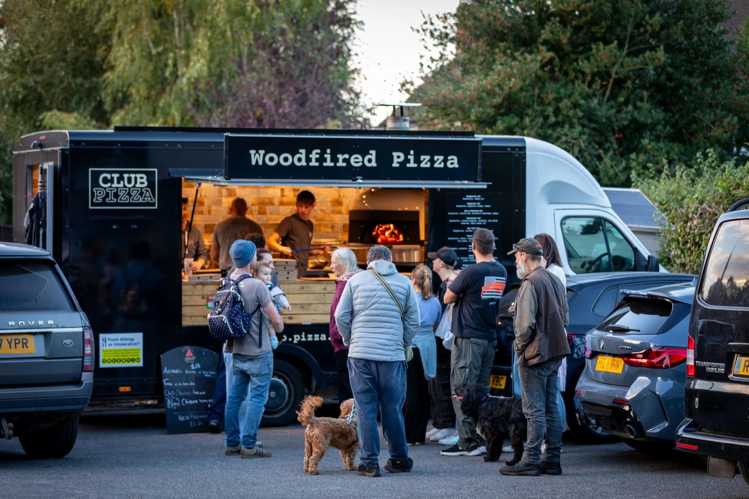 Customers queuing for pizzas at the Club Pizza van parked at The Crossways Inn, Churt, Surrey. Food & lifestyle photography by Sequoia Studios