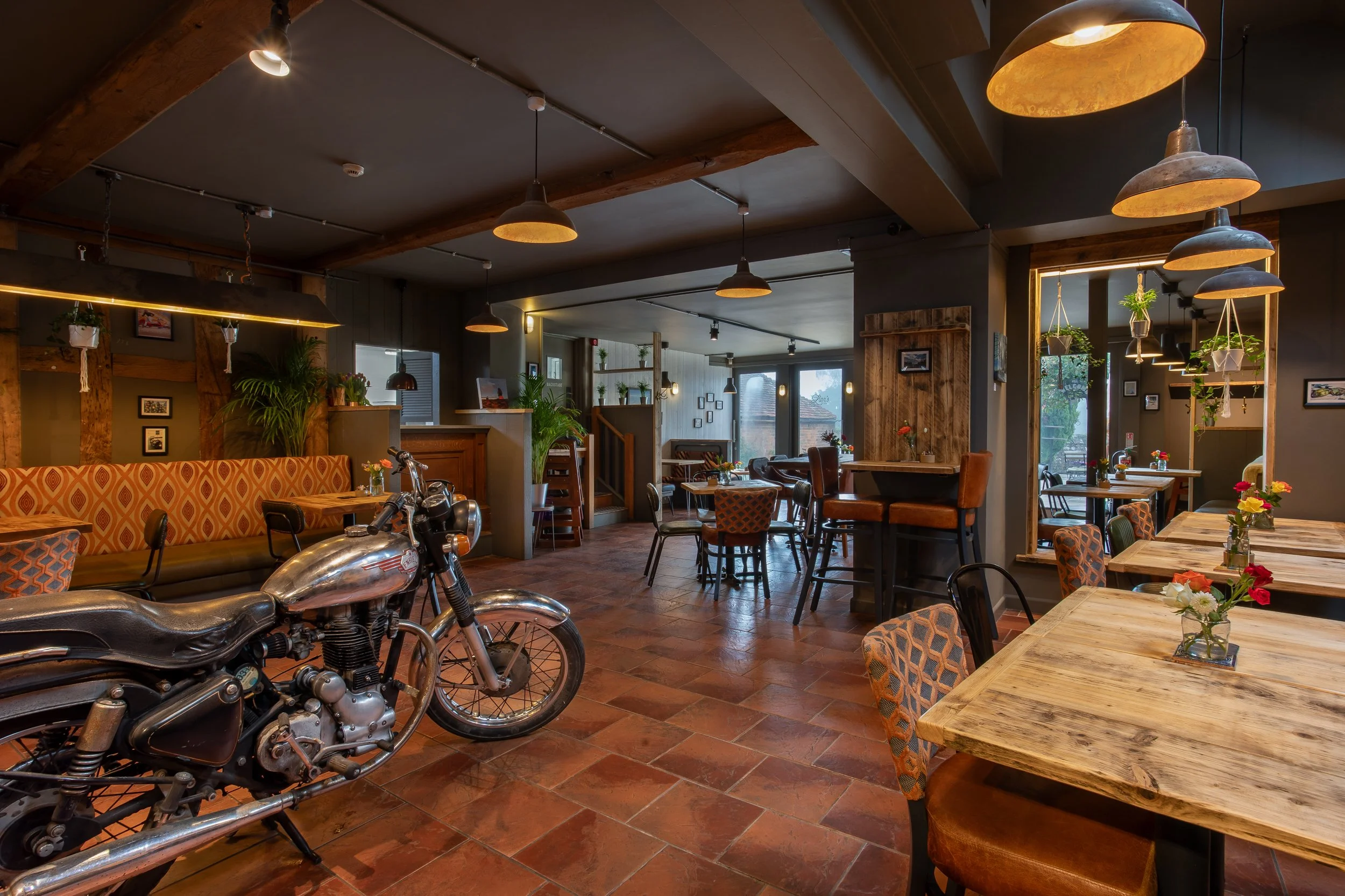 Wide angle of café interior featuring Royal Enfield motorcycle – The Lion's Den Midhurst – Hospitality Venue Photography by Sequoia Studios
