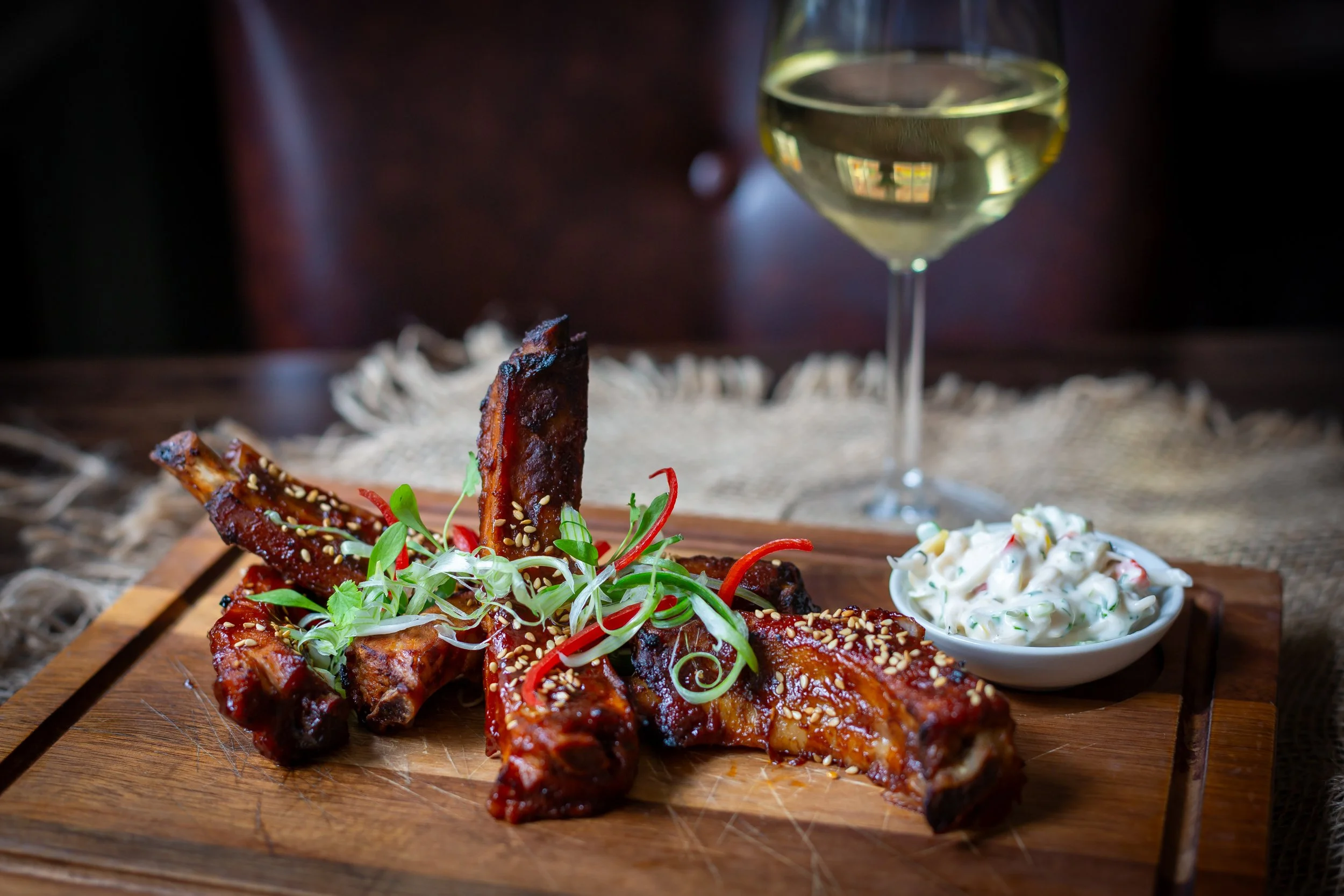 Landscape shot of Korean-style pork ribs paired with white wine at The Wheatsheaf Inn Grayswood, Surrey – Food Photography by Sequoia Studios