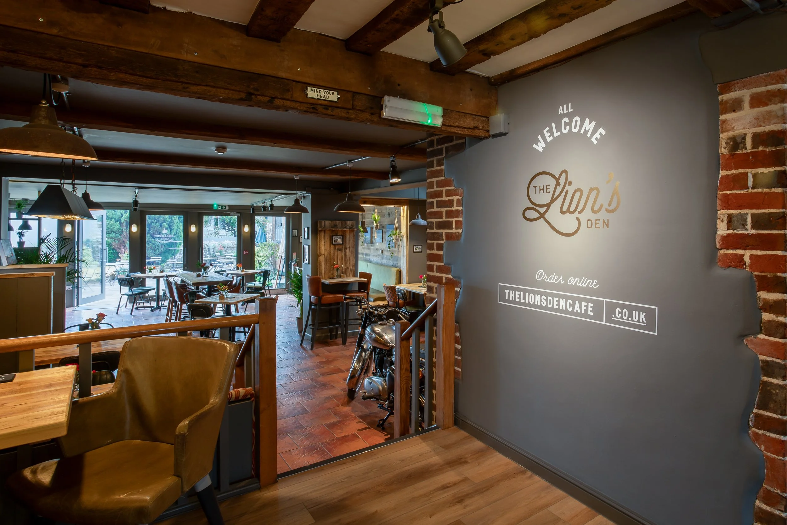 Close shot of interior with large wall featuring logo – The Lion's Den Midhurst – Hospitality Venue Photography by Sequoia Studios