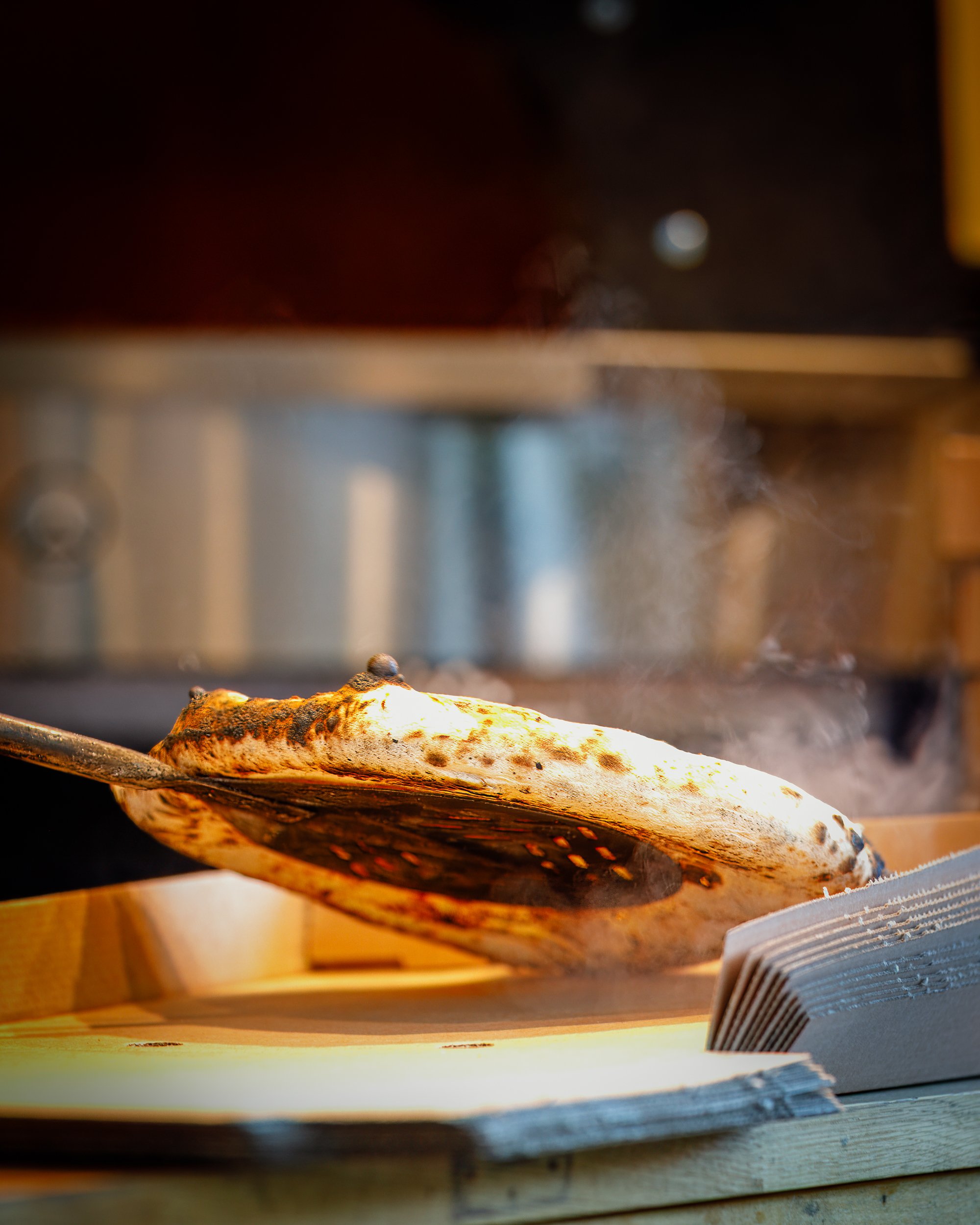 Pizza fresh out of the wood-fired oven from the Club Pizza van at The Crossways Inn, Churt, Surrey. Food photography by Sequoia Studios