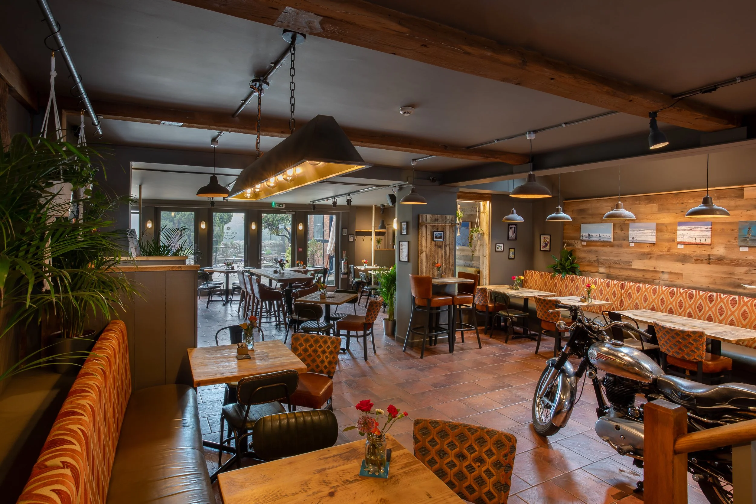 Wide shot of café interior featuring Royal Enfield motorcycle – The Lion's Den Midhurst – Hospitality Venue Photography by Sequoia Studios