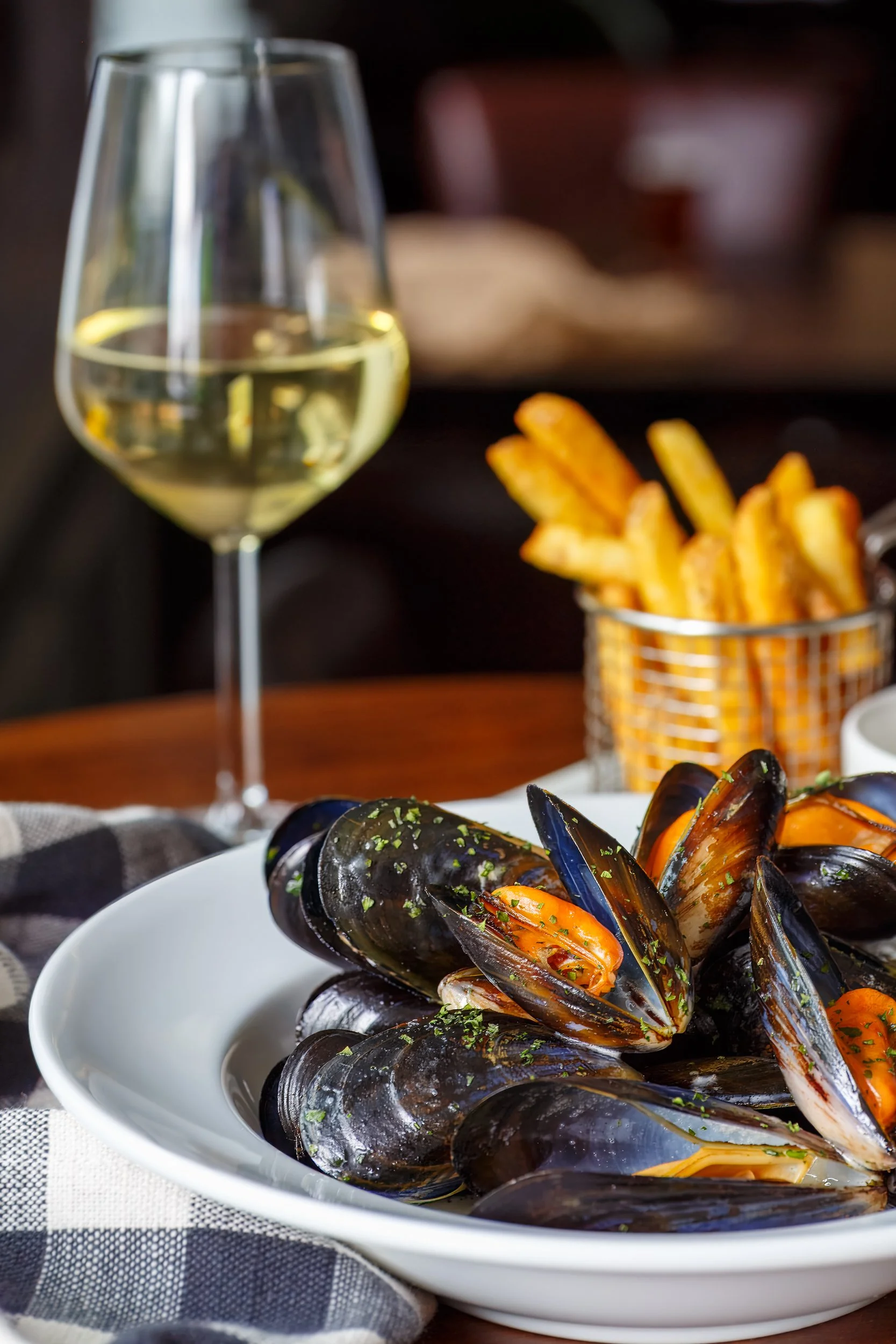 Portrait photo of freshly prepared Moules Mariniere with frites, paired with white wine at The Wheatsheaf Inn Grayswood, Surrey – Food Photography by Sequoia Studios