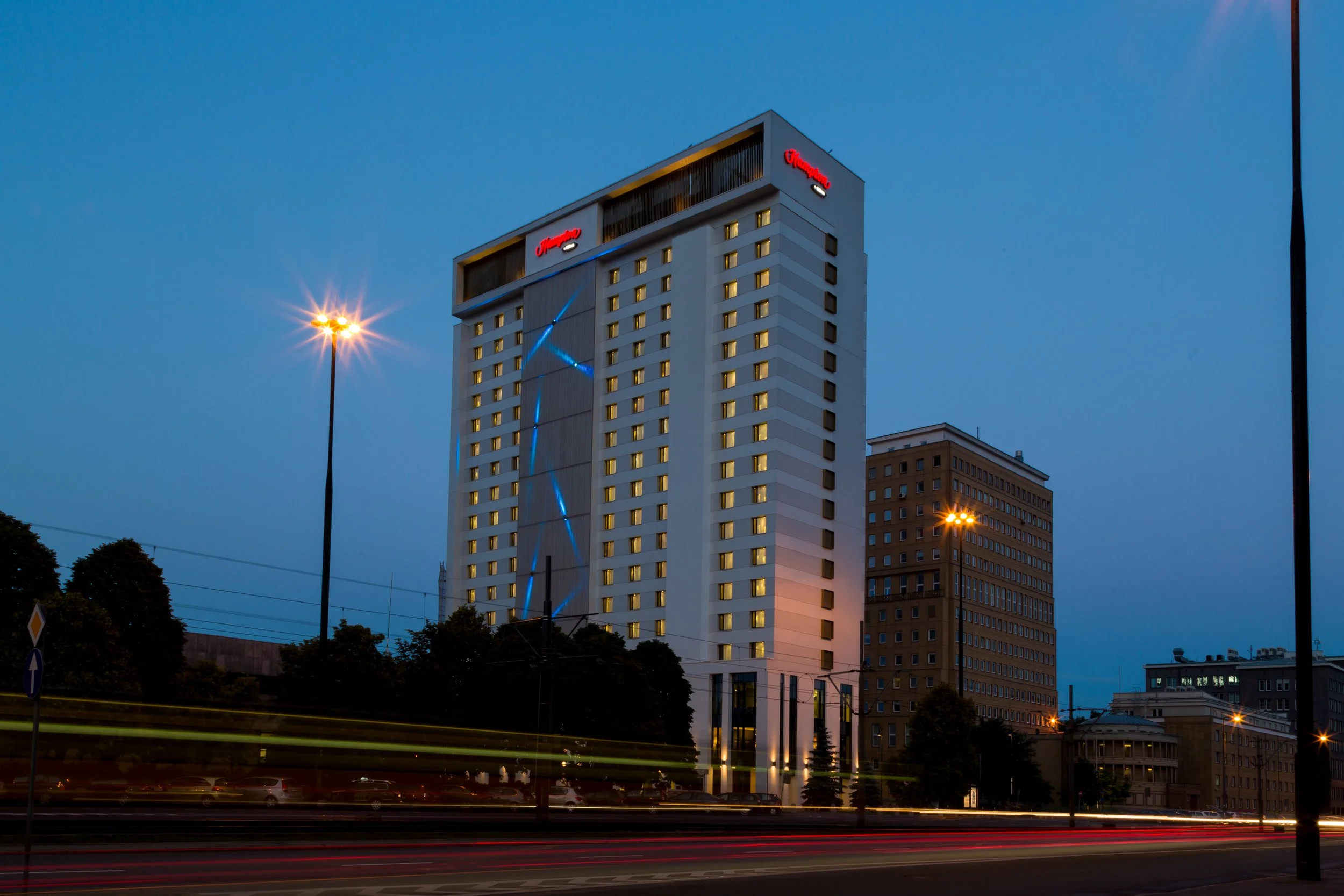 Long exposure of evening exterior of Hampton by Hilton hotel in Warsaw, Poland with the local tram passing by in the foreground
