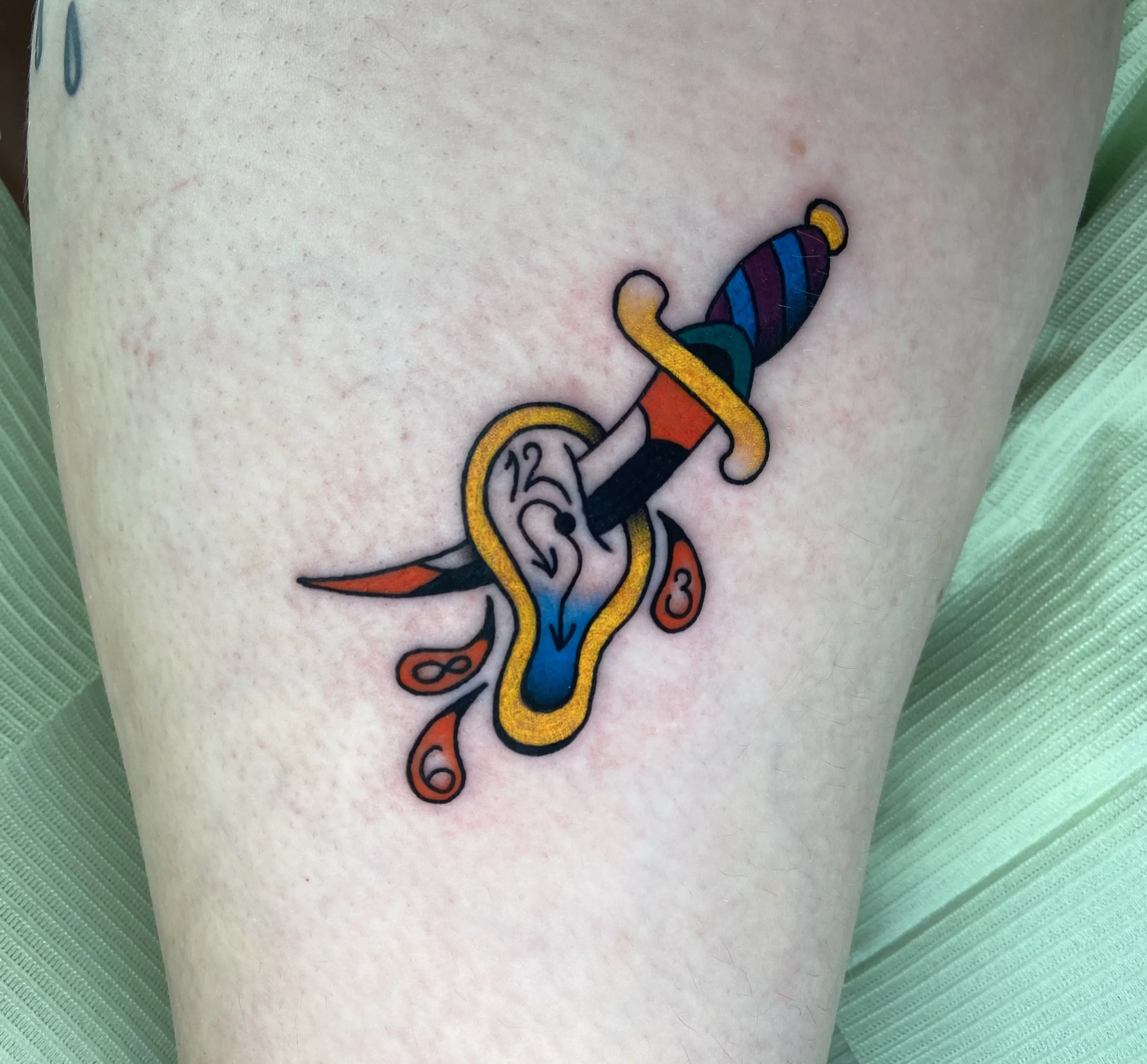 Colorful tattoo of a dagger piercing a melting clock with orange and red accents.
