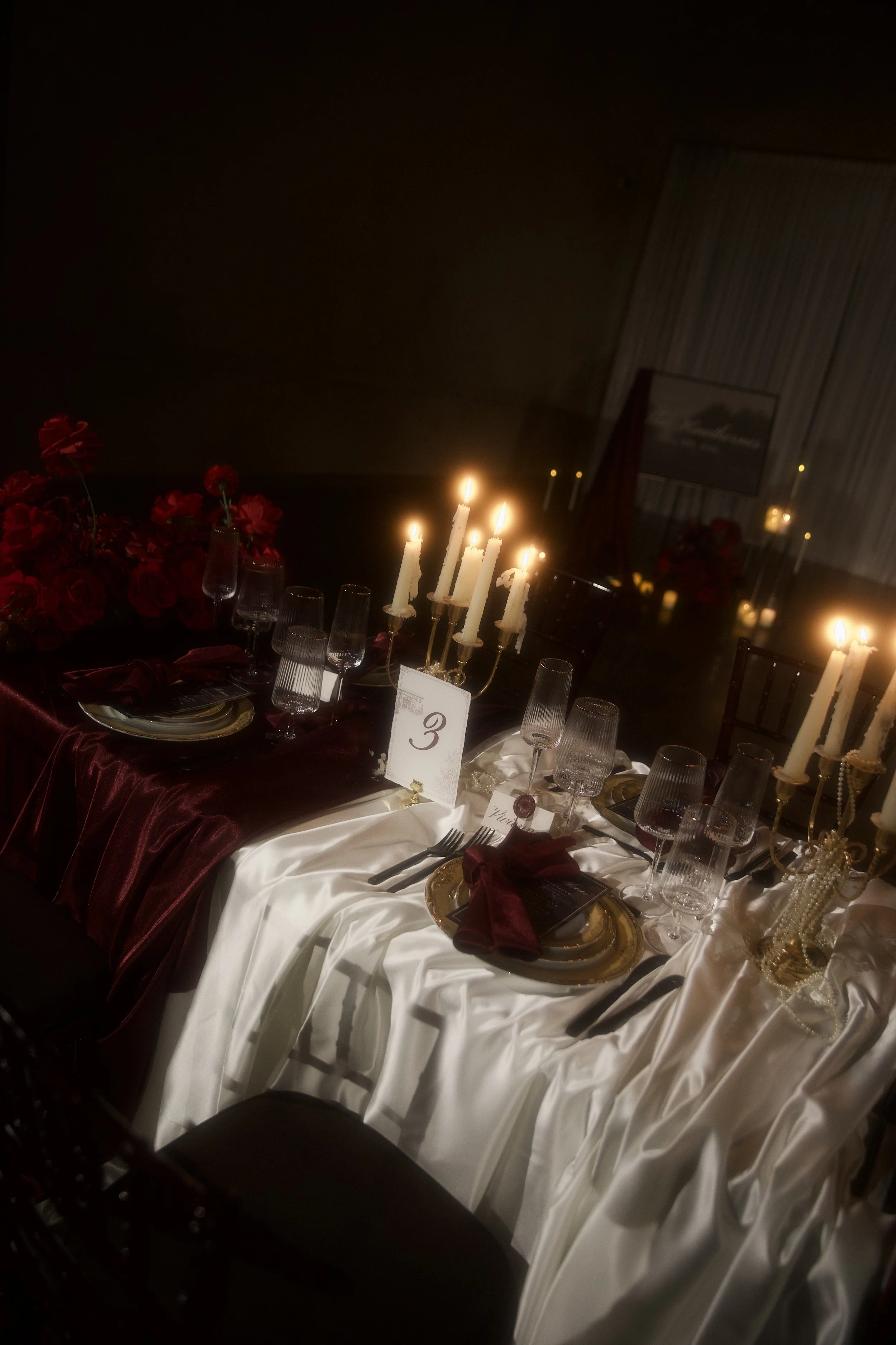 A dramatic  floral installation featuring deep red roses, burgundy blooms, cascading amaranthus, and layered candlelight. Designed by S.R. Event Design & Decor for a dark romance styled shoot at Bella Sera Event Villa near Pittsburgh, this statement 
