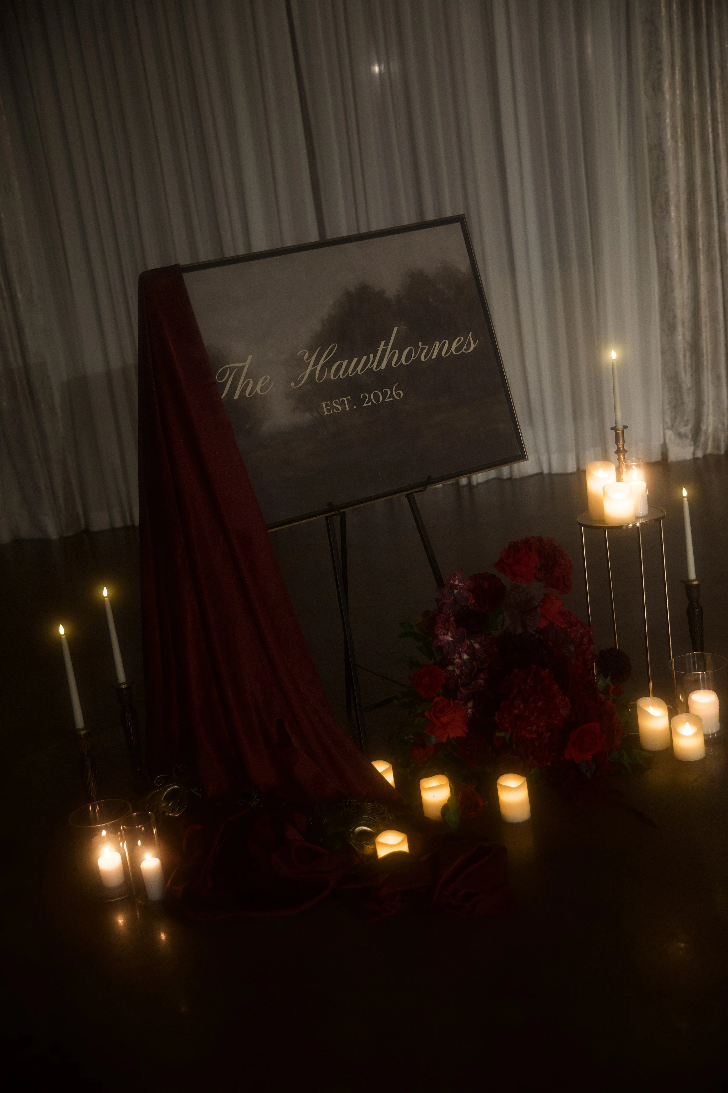 A dramatic floral installation featuring deep red roses, burgundy blooms, cascading amaranthus, and layered candlelight. Designed by S.R. Event Design & Decor for a dark romance styled shoot at Bella Sera Event Villa near Pittsburgh, this statement a