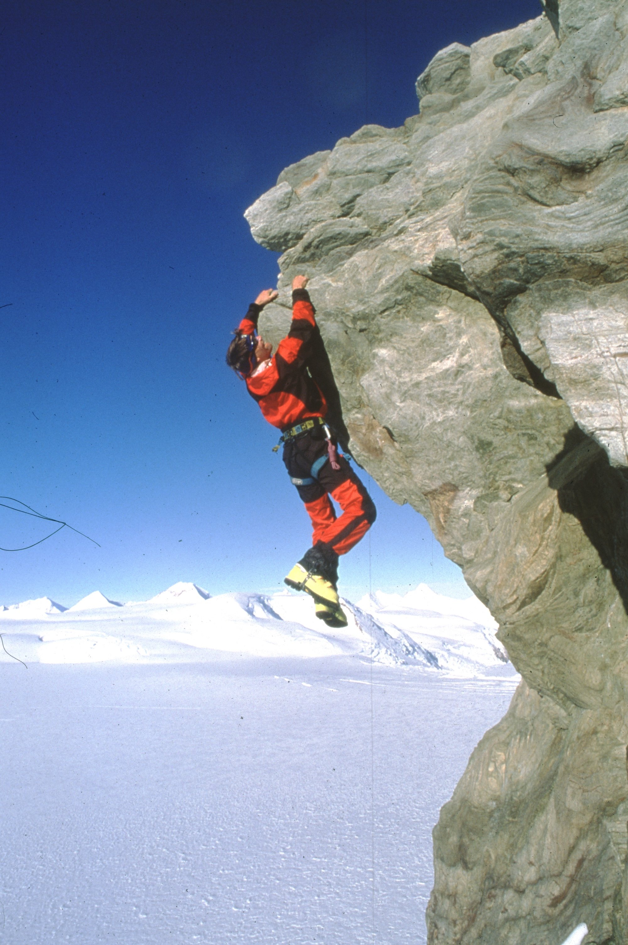  Alex Lowe hangs from a cliff edge on the summit of a peak over Patton Glacier, Ellsworth Mountains, Antarctica 1998. C: Gordon Wiltsie 
