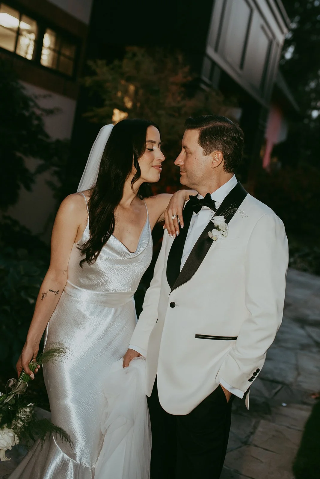 Wedding couple smiling at each other during portraits at golf course.