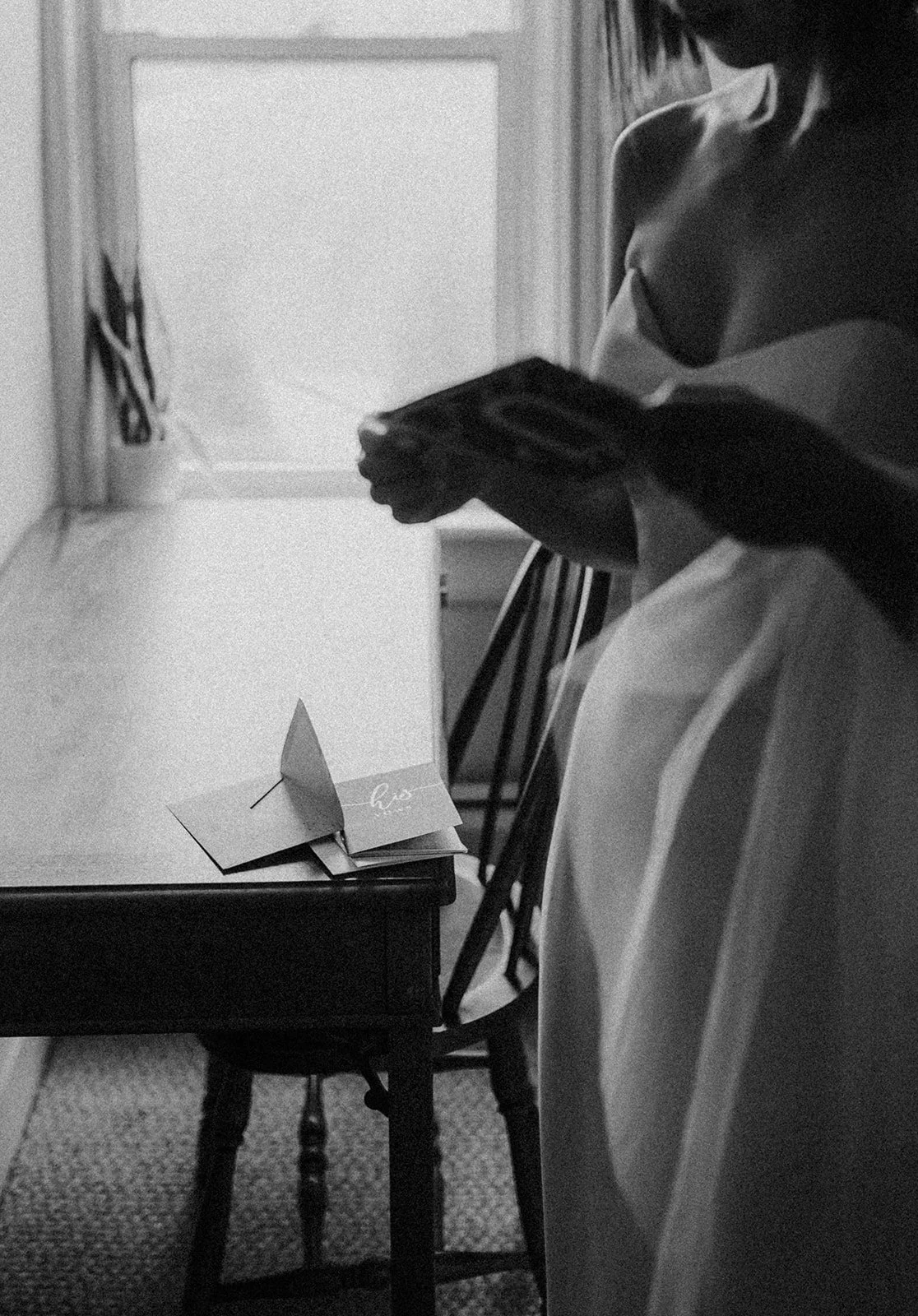 Bride reading card from groom in private moment during getting ready photos.