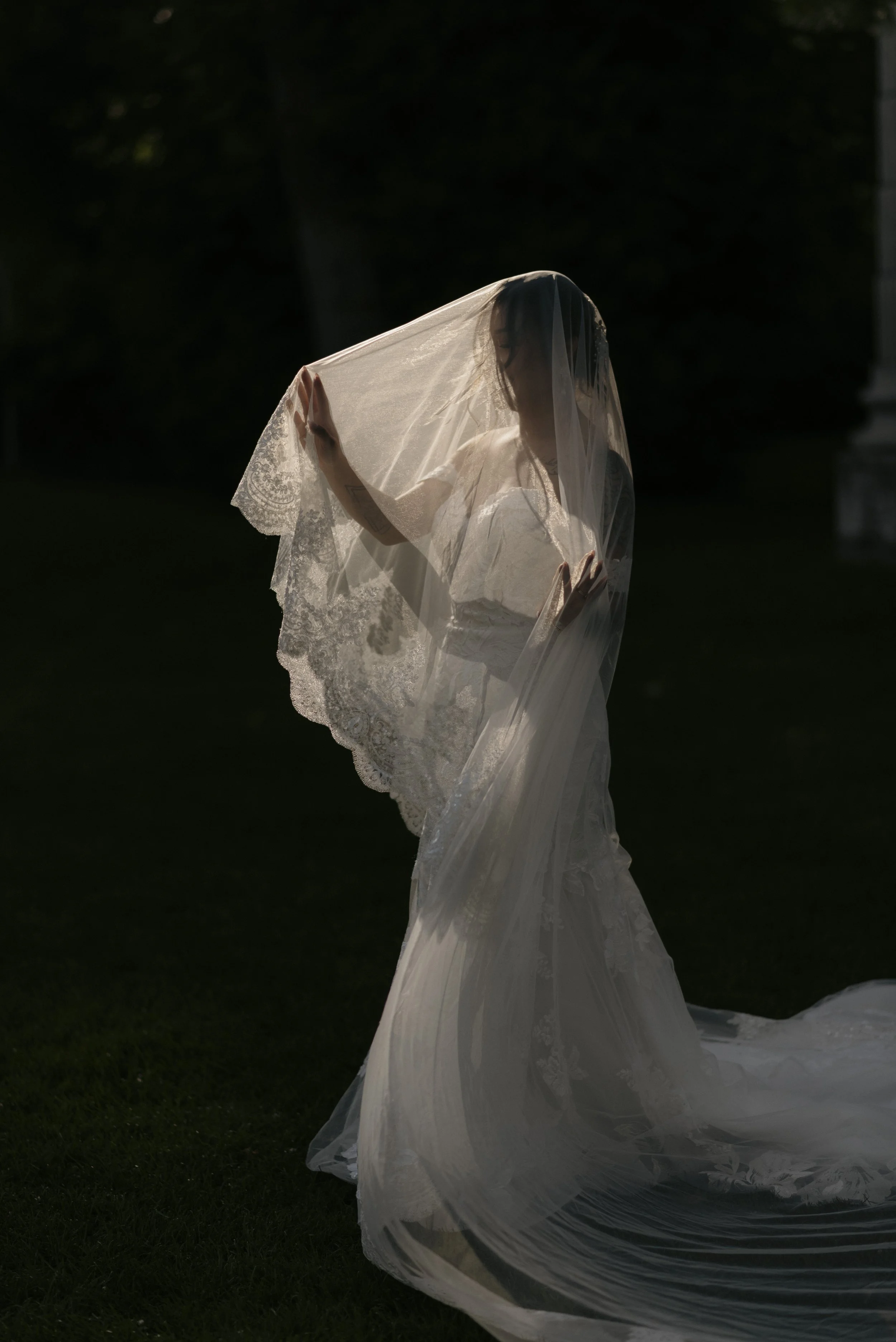 Bride in vintage wedding dress with lace veil in the afternoon sun at the Guild Inn in Toronto, Ontario.