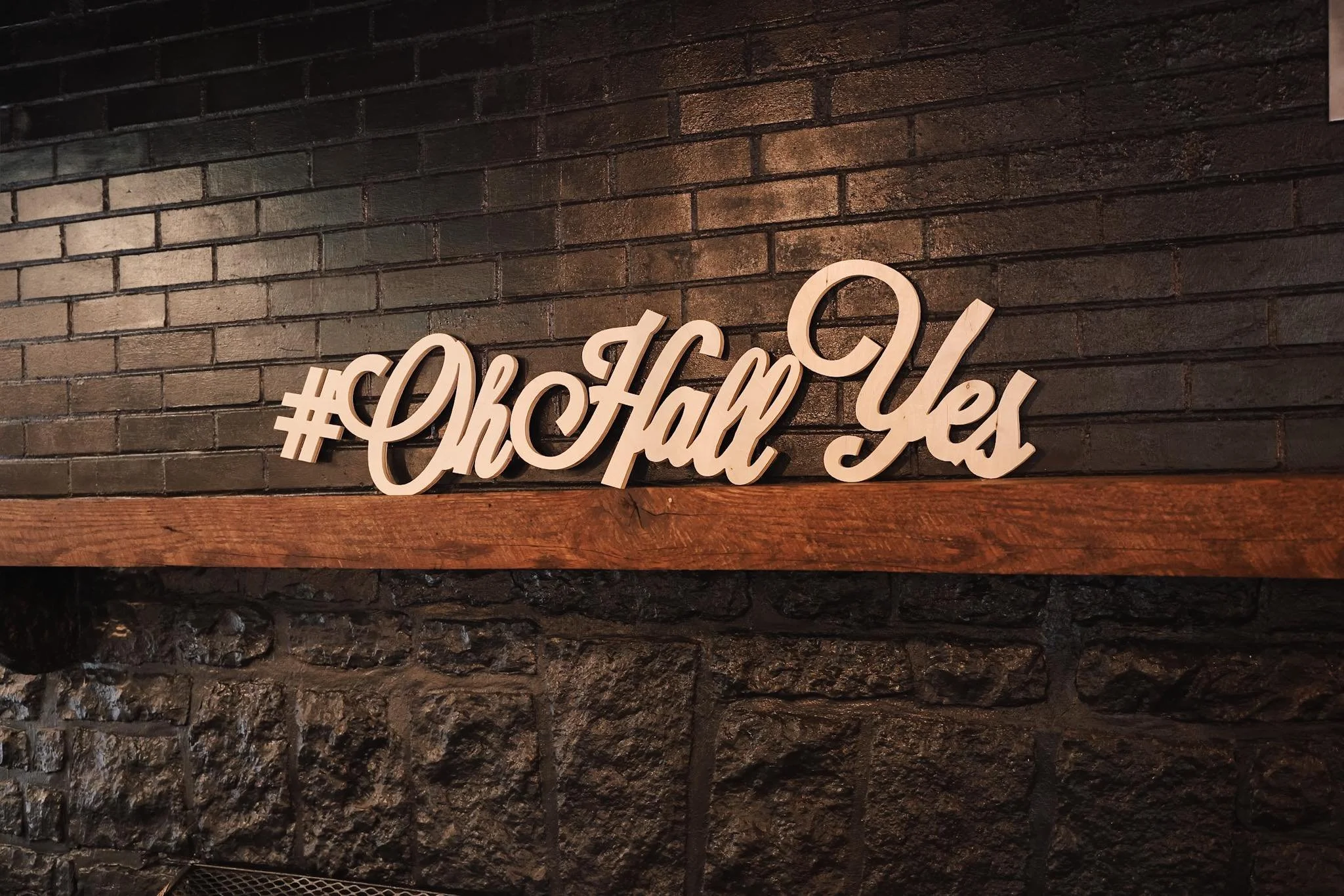 Decorative hashtag sign reading '#ChCh Has Yeo' on a brick wall.