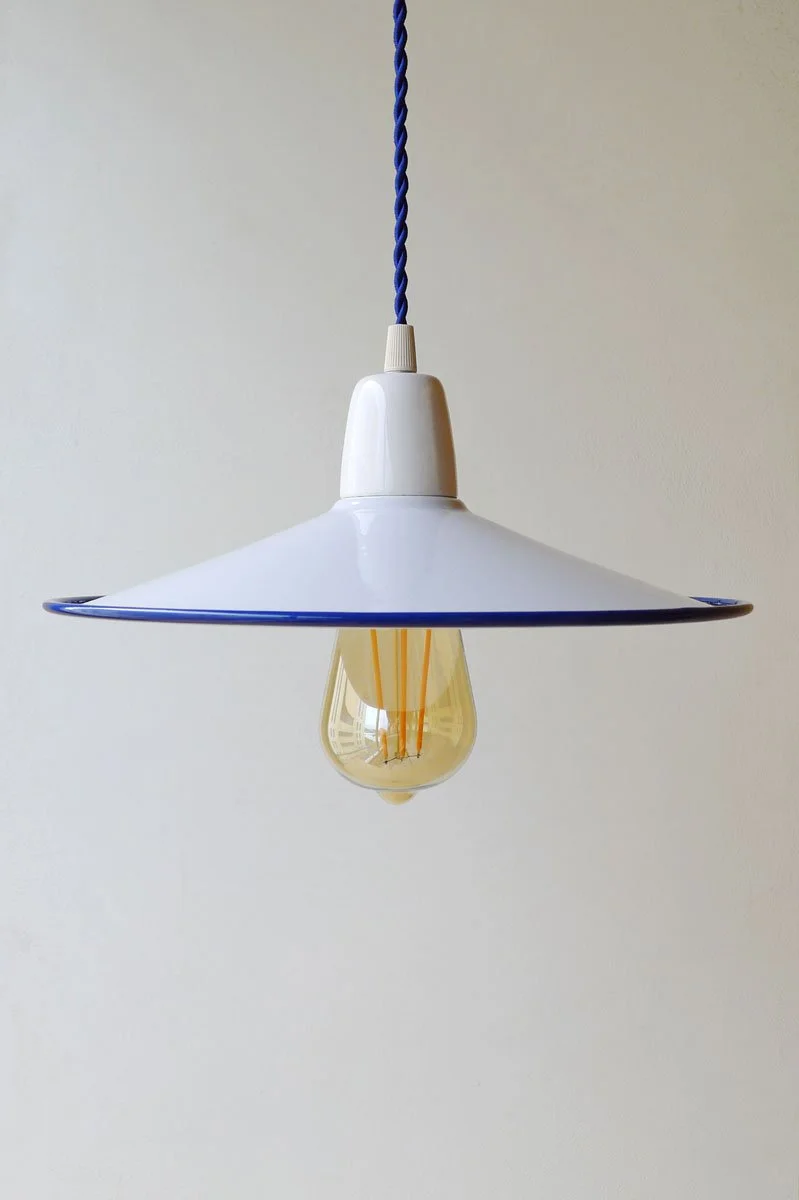 A white hanging pendant lamp with a conical shade, a blue twisted cord, and an exposed filament bulb.