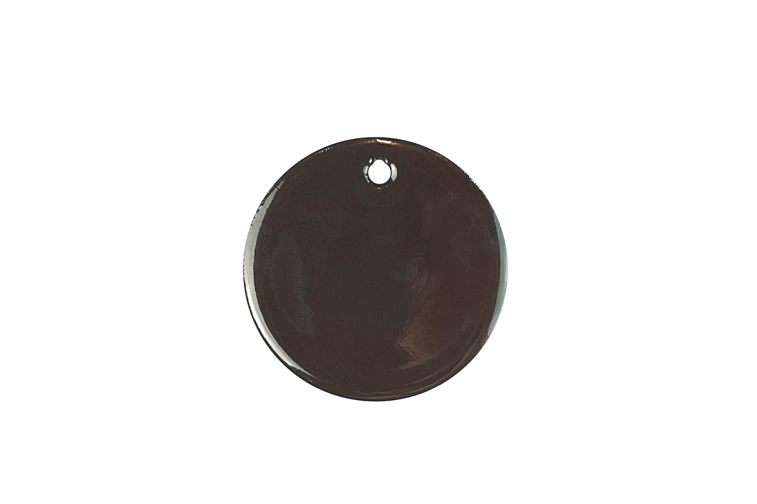 Close-up of a round dark-grey enamel sample with a hole near the top, set against a white background.
