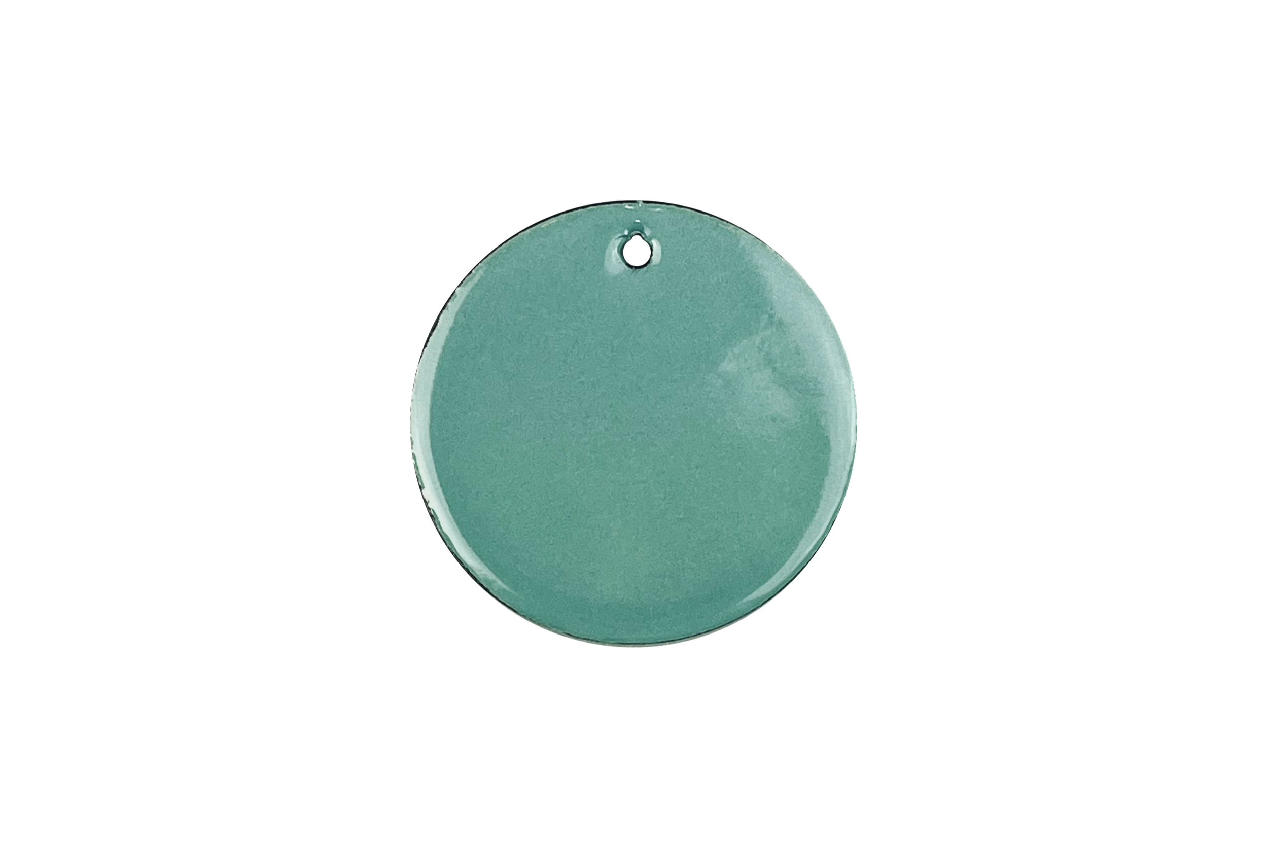Close-up of a round mint-green soap or cosmetic product with a metal loop at the top on a black background.