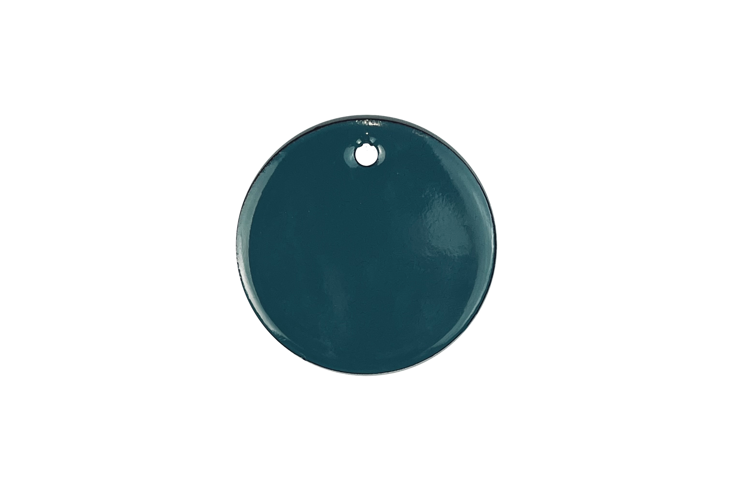 Close-up of a small, round, teal-colored object with a tiny black hole at the top, isolated against a black background.