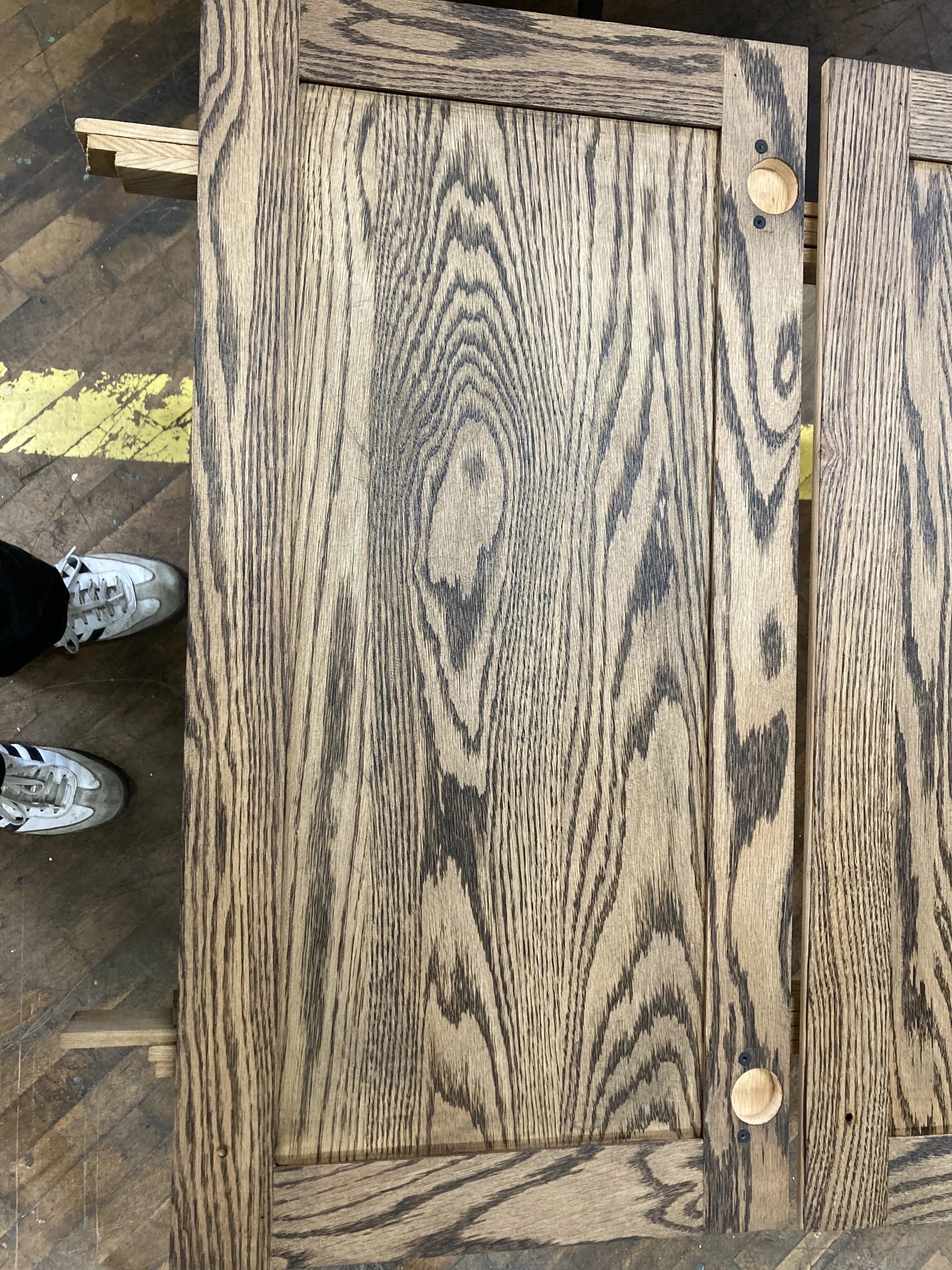 Wood panel with visible grain and frame, partially constructed, with two small holes on the right side.