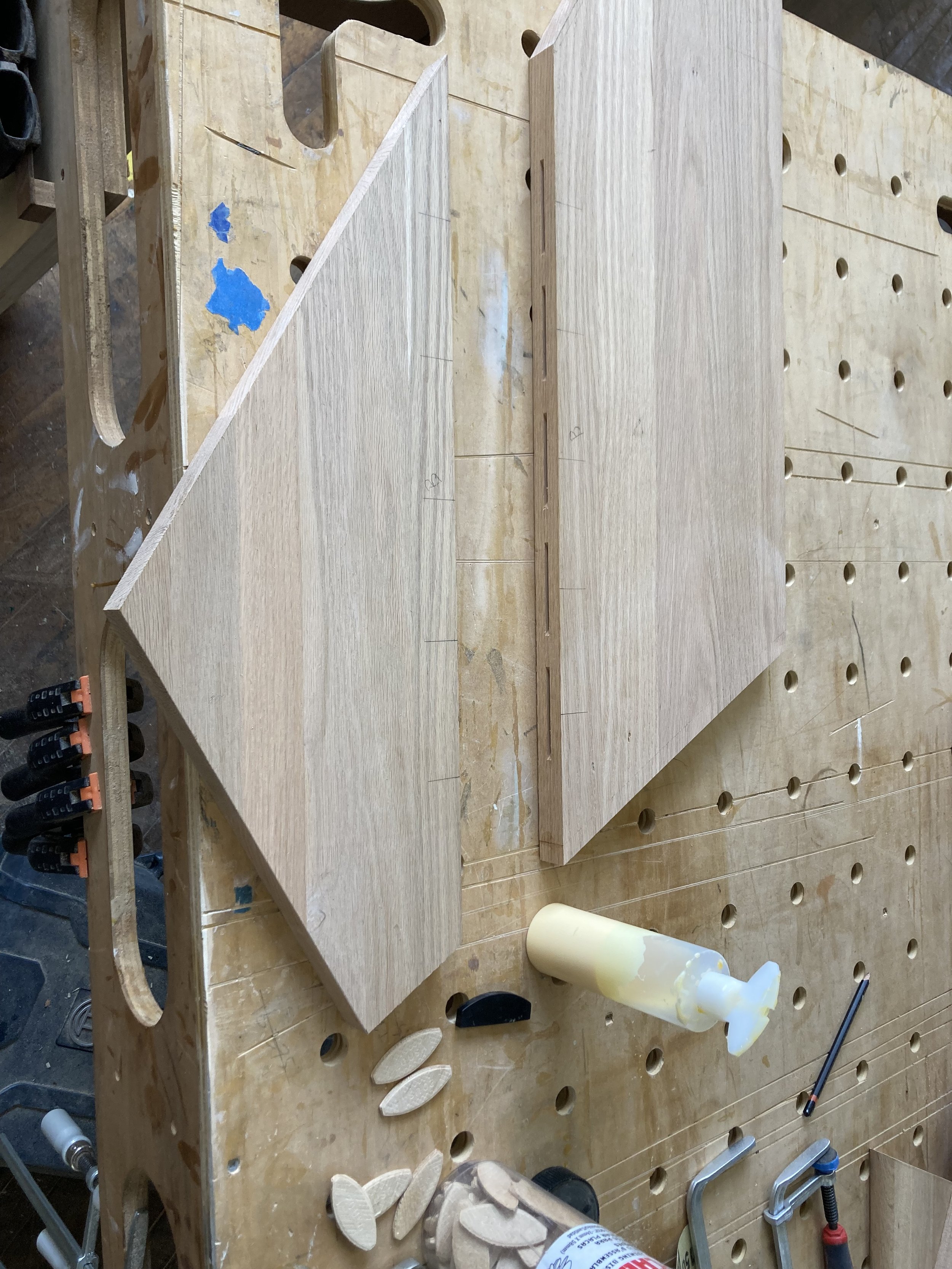 Woodworking table with wooden panels, wood glue, dowels, and clamps