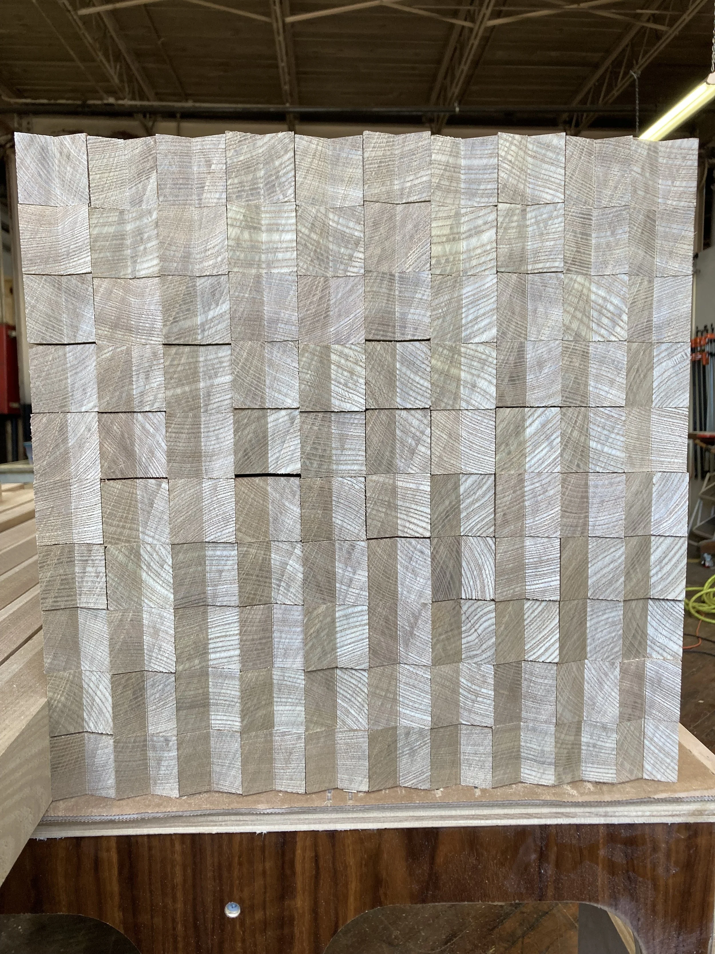 Stacked wooden blocks with visible grain patterns in a geometric arrangement.