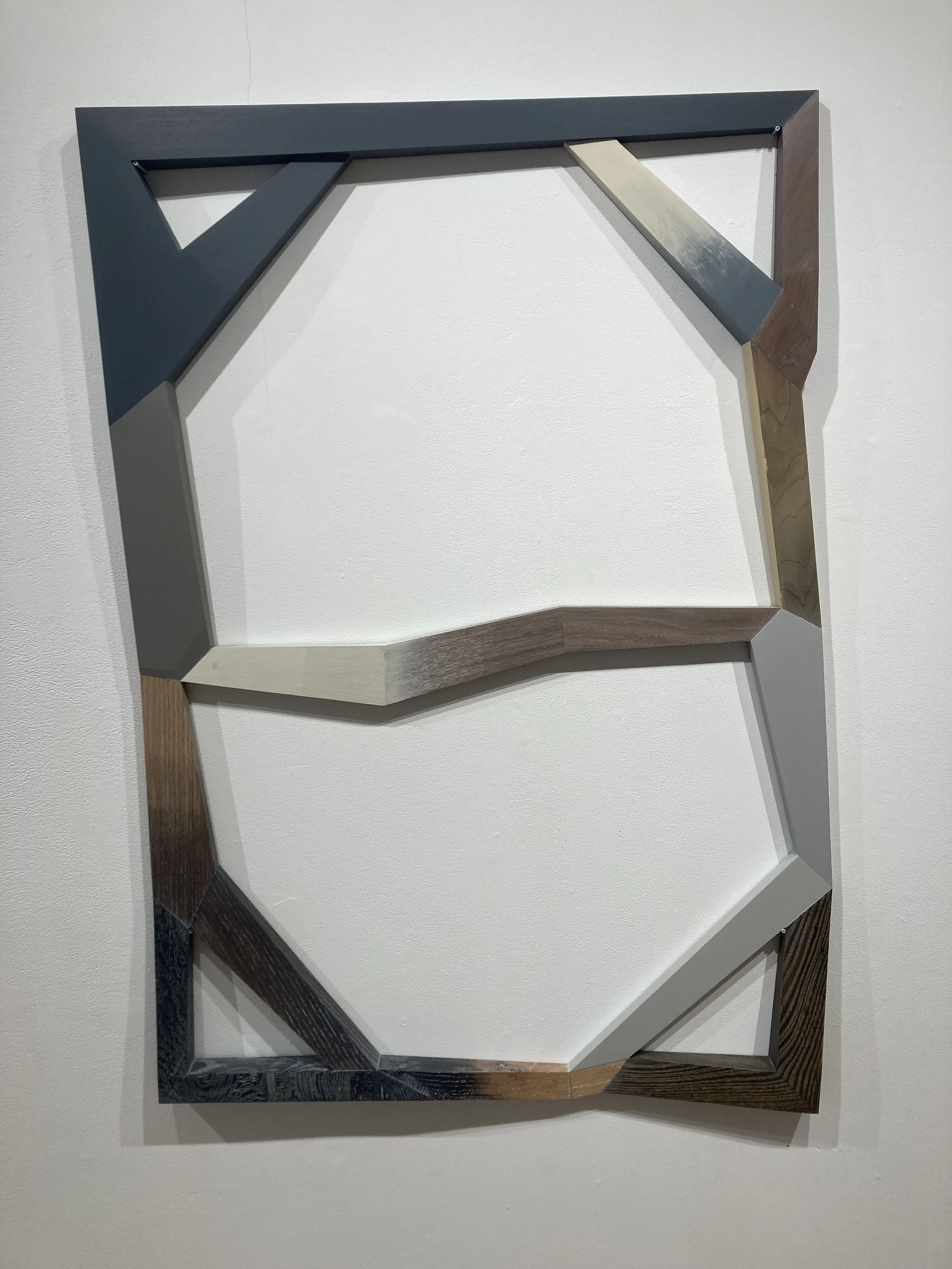 Abstract geometric wooden frame on white wall