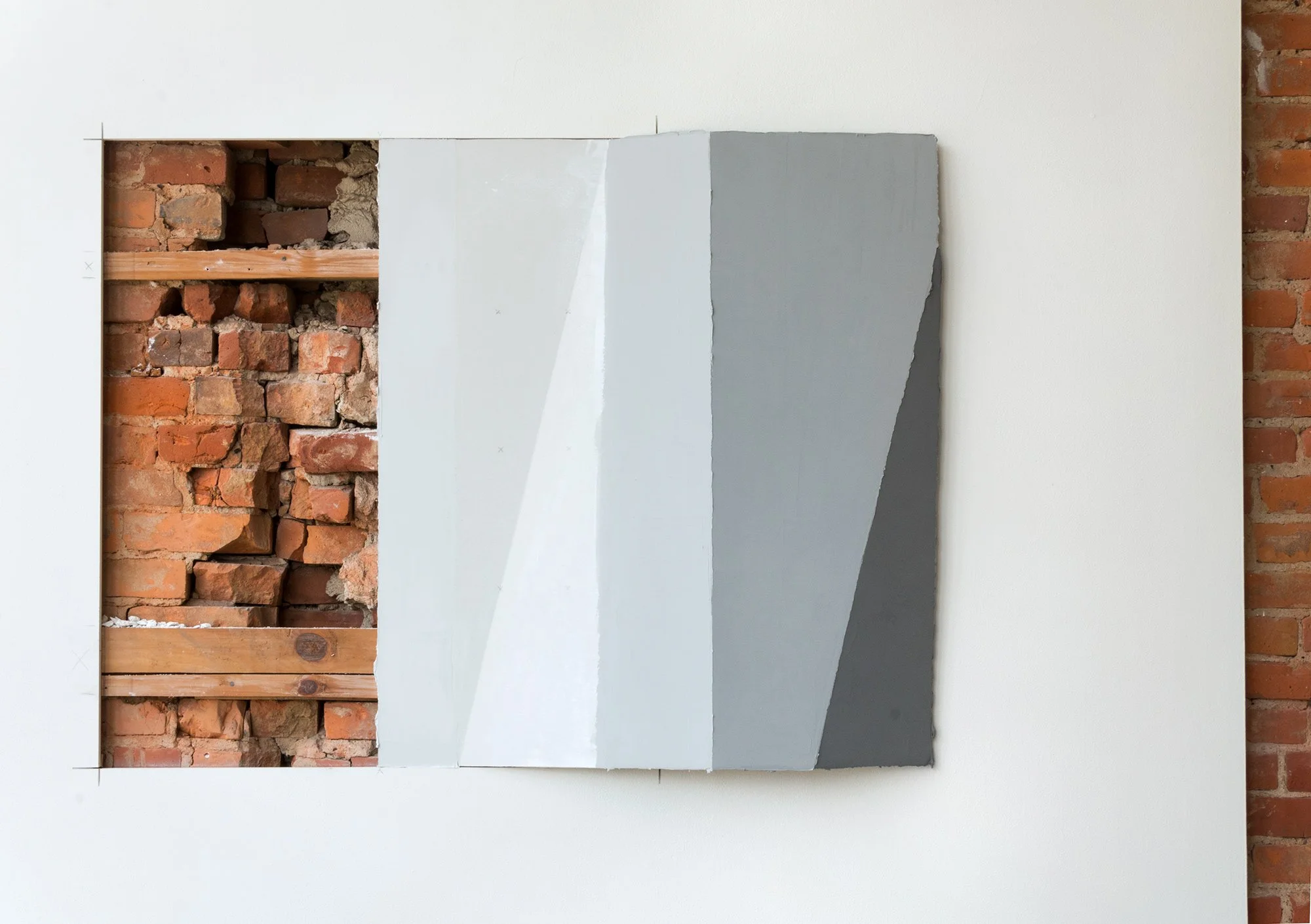 Exposed brick wall with painted gray panels.